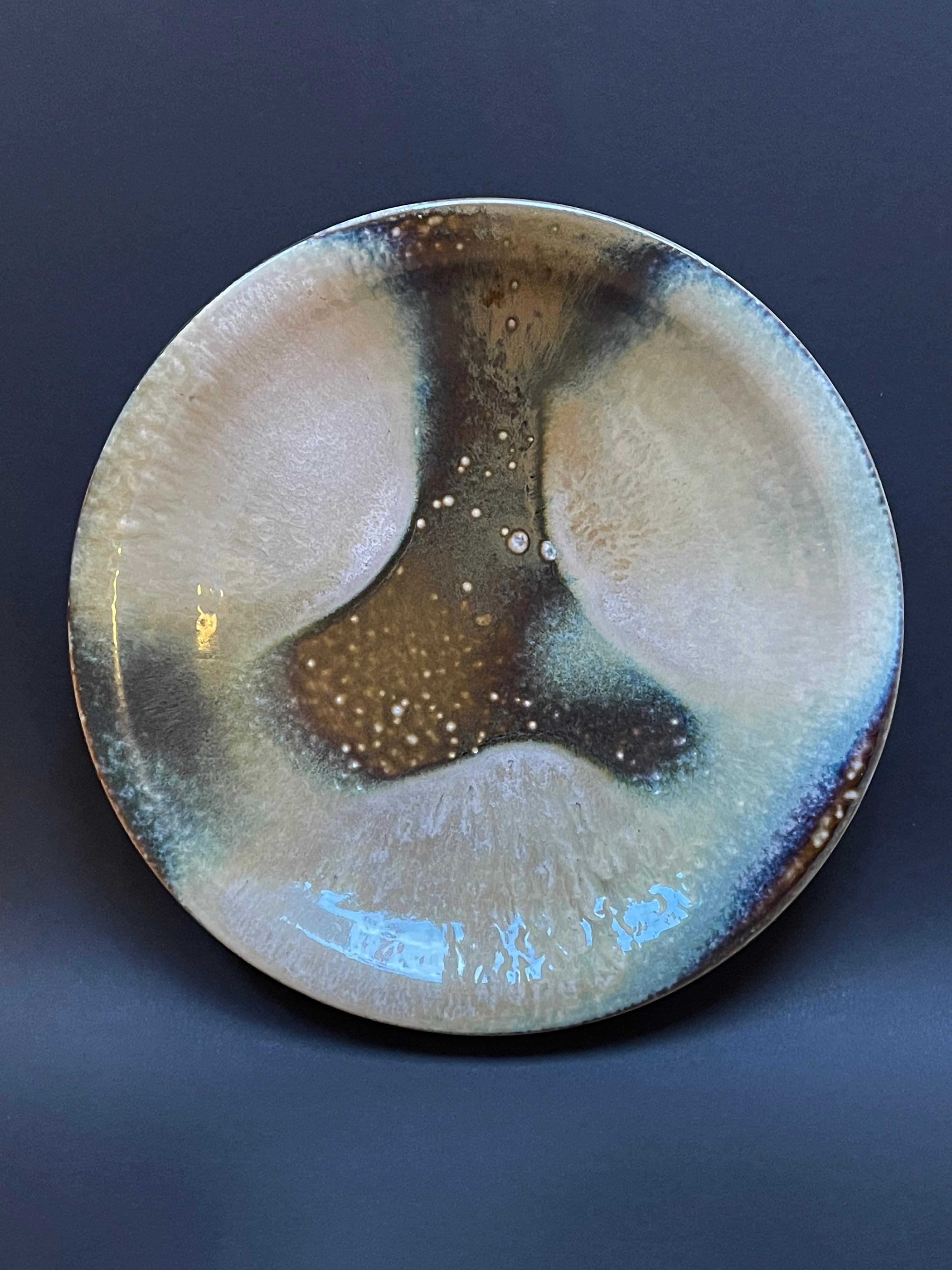A truly unusual piece of art is this large hand-thrown bowl or serving plate from ceramic, with a vibe of Japanese design.
Beautiful decorative and timeless, glazed in a classic mid-century colour scheme with beiges, olive and turquoises, I locate