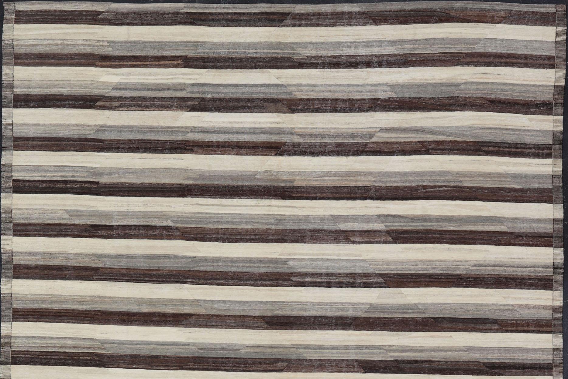 With a modern casual feel to a traditional Kilim pattern, this piece features a horizontal striped pattern, repeating in ivory, taupe, and dark brown. These complimentary colors and modestly modern design would suit a various range of interiors.