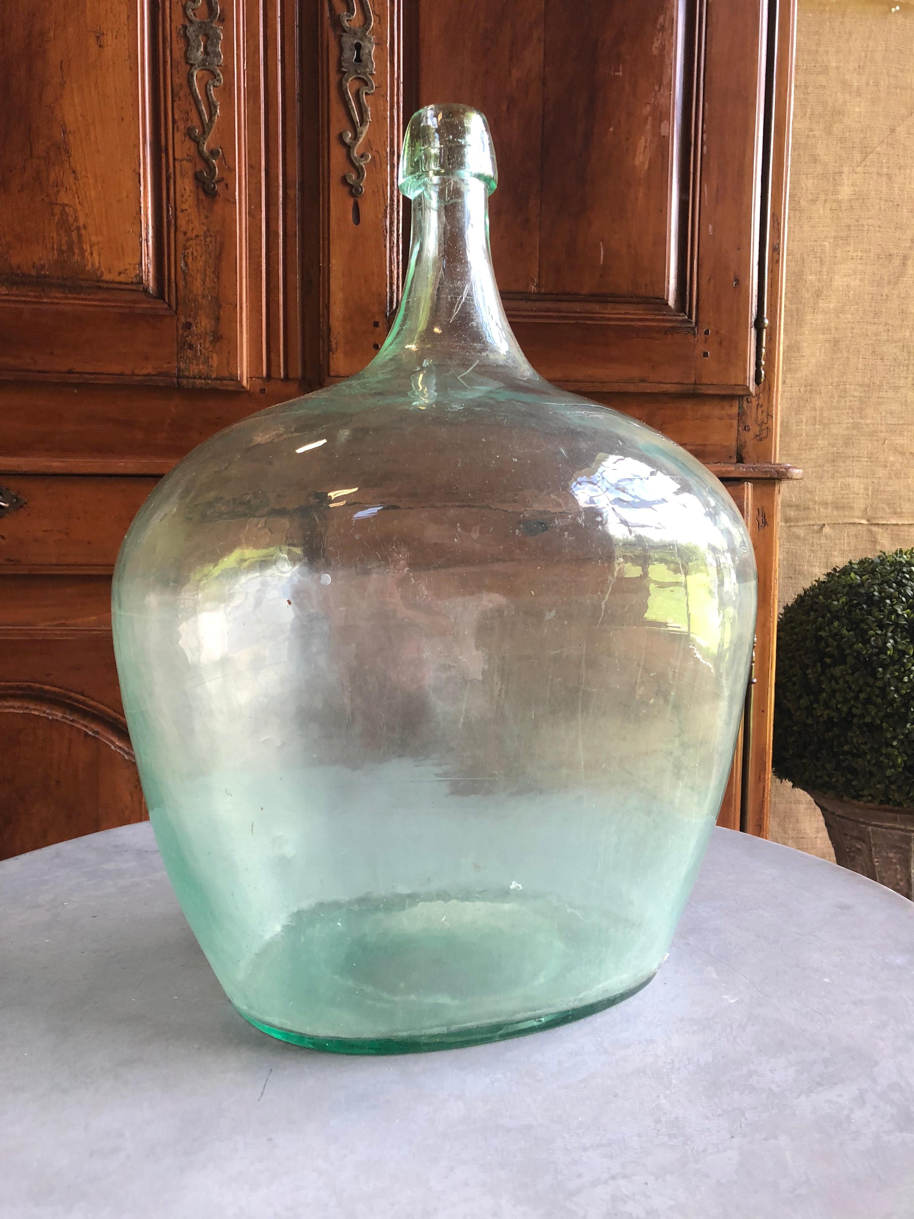 A large handblown aqua glass demijohn bottle, possibly European, circa 1870.