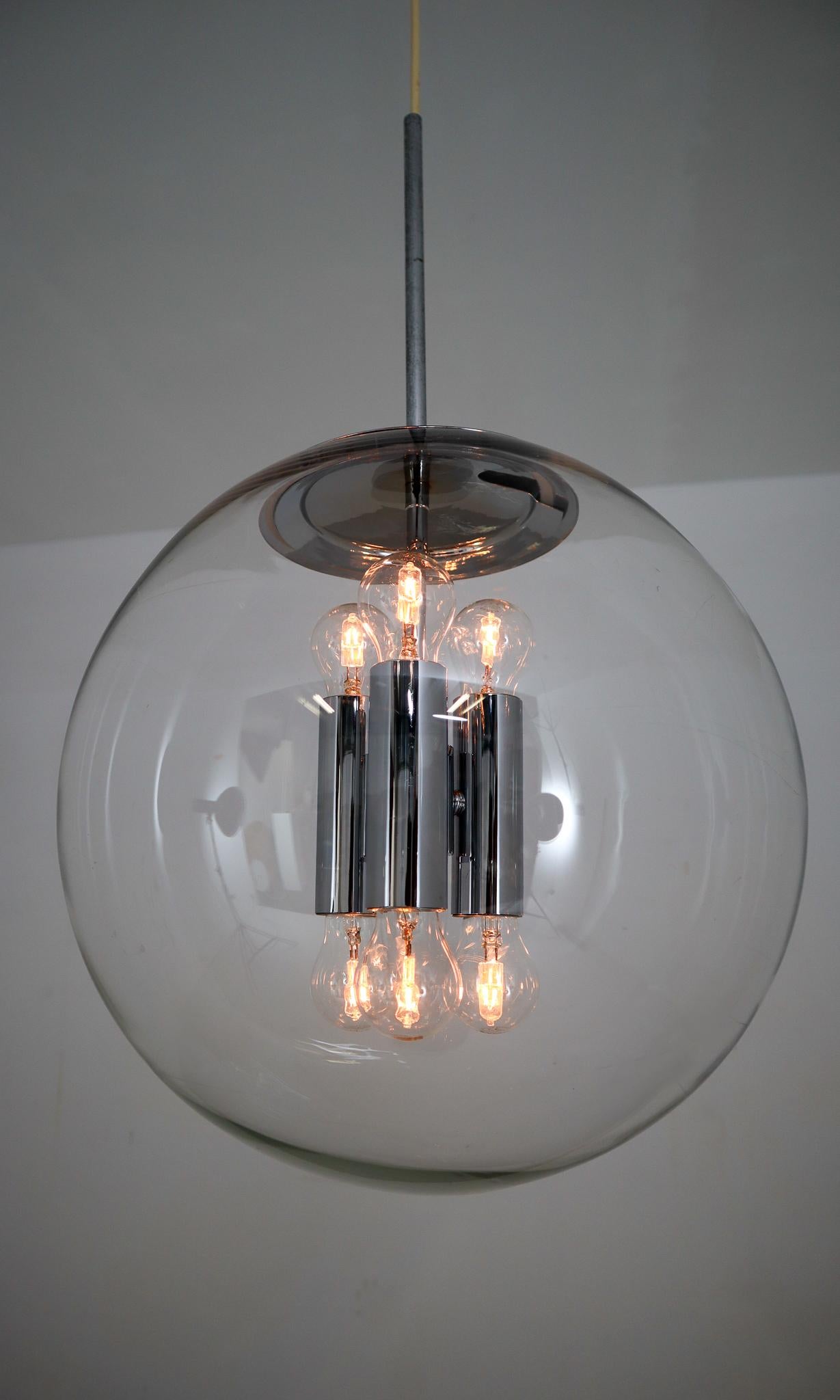 This large set hand blown pendant lamps were made by the German manufacturer Limburg Glashütte in the 1970s. The hand blown glass globes are mounted on a chrome base. These heavy quality light sculptures not only function as light sources but also