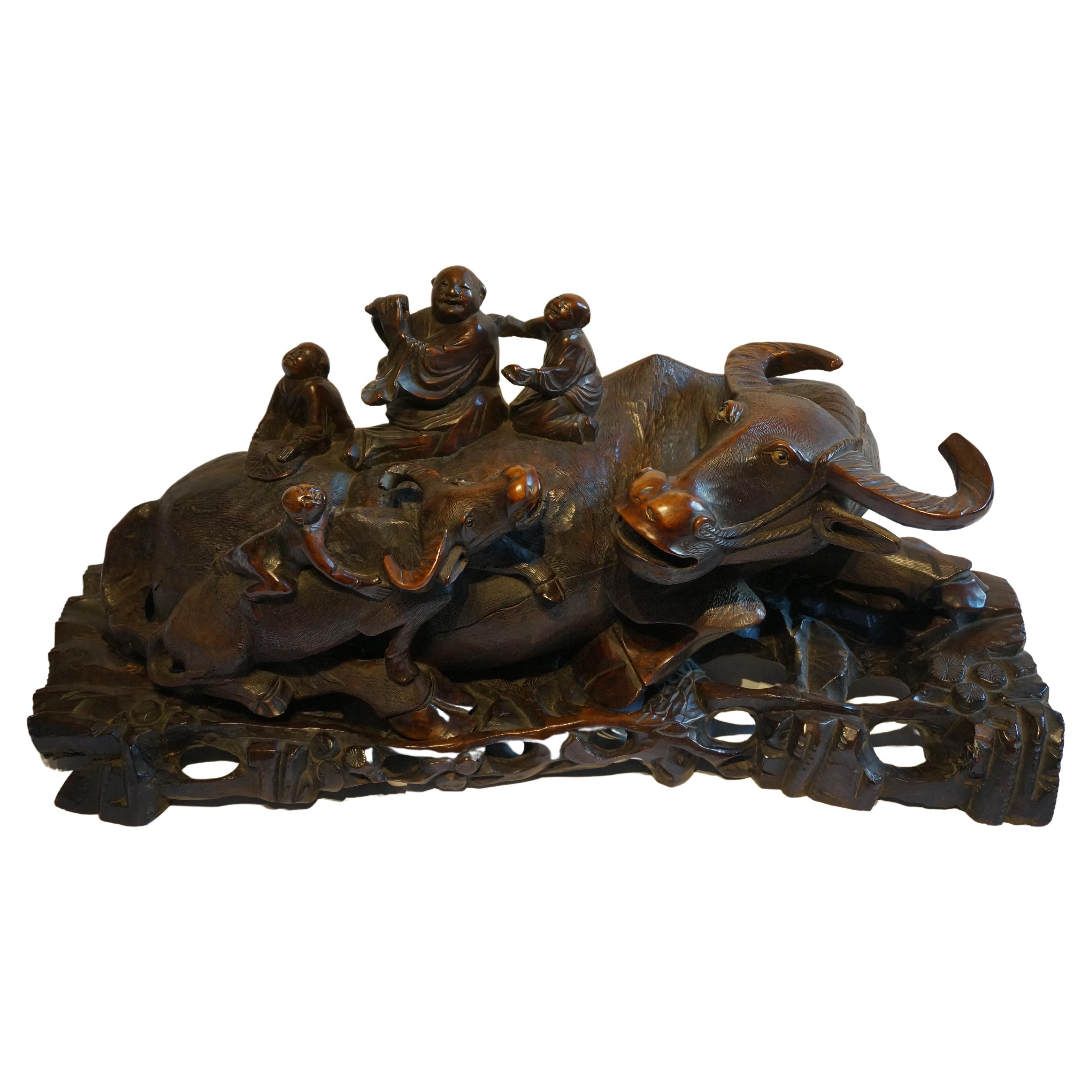 Large handcarved Asian wooden sculpture of a water buffalo with calf and figures