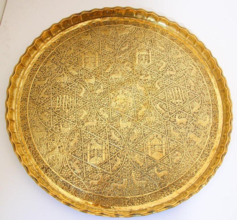 Large antique 19th century handcrafted decorative Indo-Persian Mughal brass tray.
Asian metalwork finely embossed and hammered with floral and figural and animals mystique scenes and Arabic calligraphy repousse writing in medallions.
Large