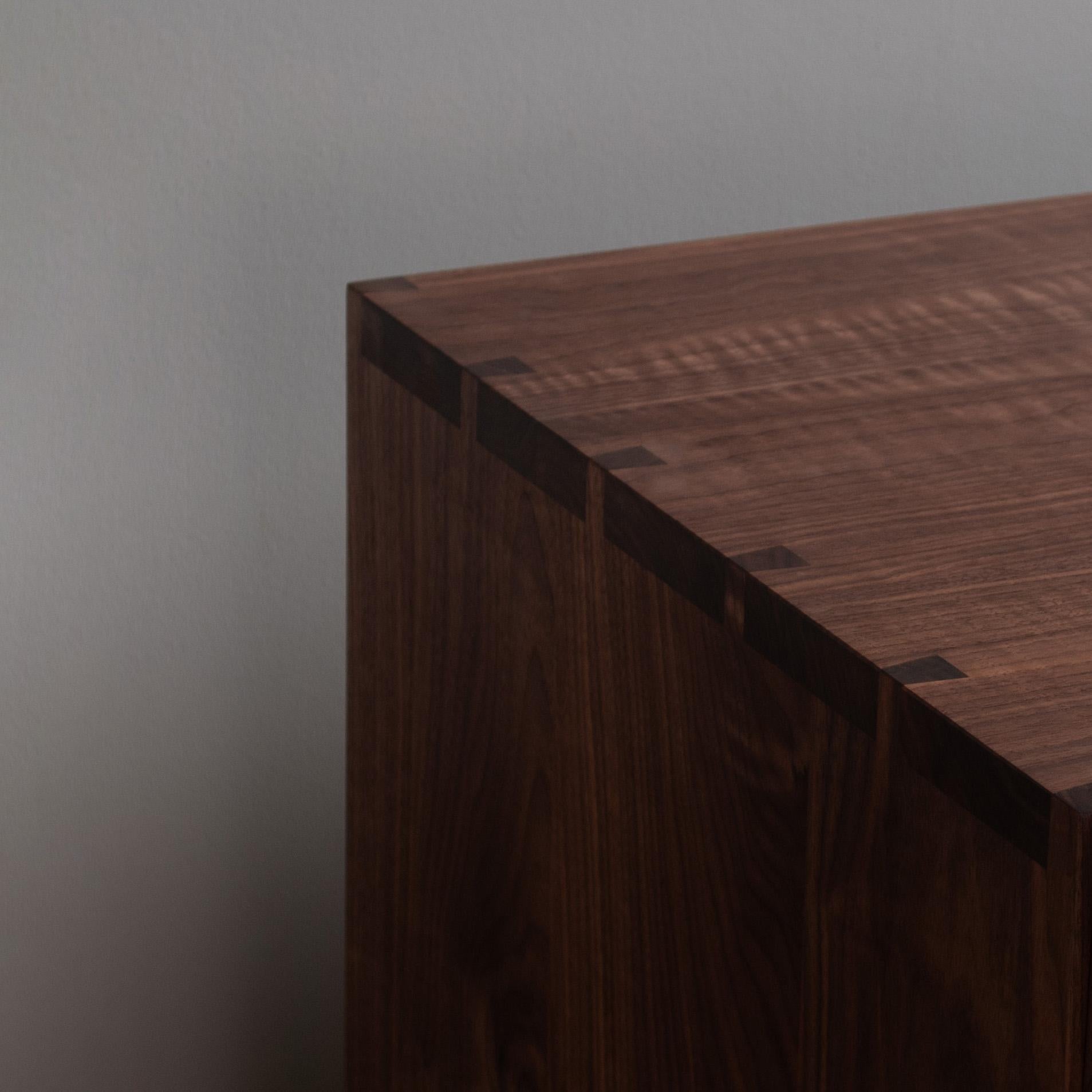 Our large handcrafted AMC sideboard credenza with visible hand-cut dovetail jointing to main surfaces. Two soft close drawers with internal oak carcasses and three cupboards below with internal shelves. 
We carefully select the walnut so that it
