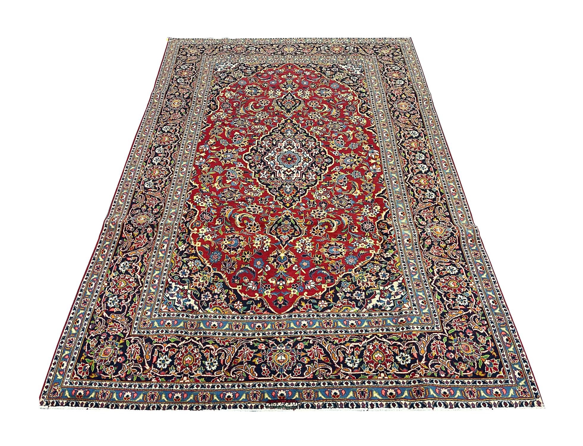 This elegant, rich red rug features a highly-detailed all over and surrounding design. It is decorated with a beautiful array of floral motifs woven symmetrically to create a decorative masterpiece. The enclosing border is woven on a contrasting