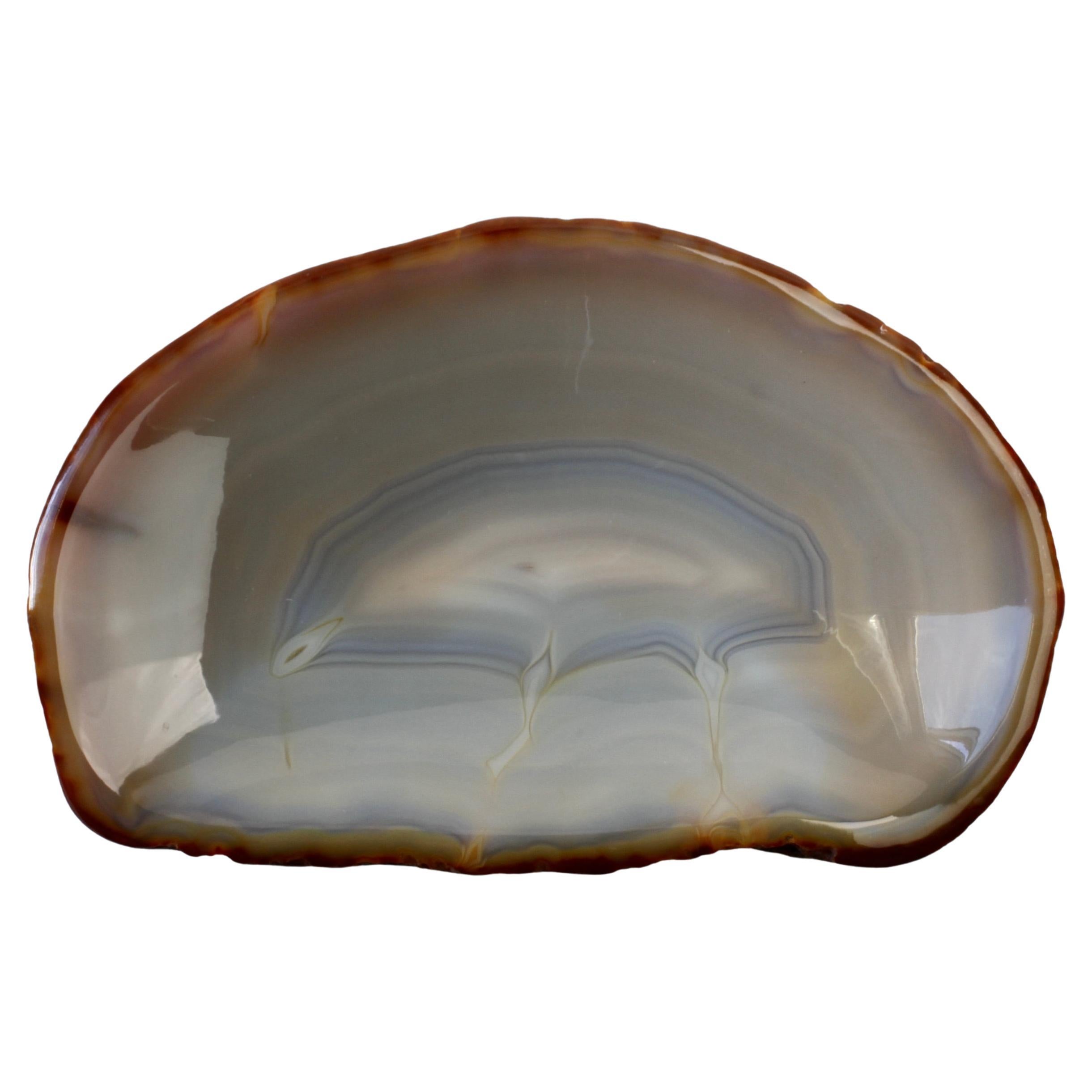 Magnifique plat, bol ou vide-poche en agate bleue sculptée, façonnée et polie, de facture inconnue. Merveilleuse forme organique légèrement ovale avec des lignes chaudes ou des anneaux de couleurs caramel, crème et bleu (couleurs). Probablement