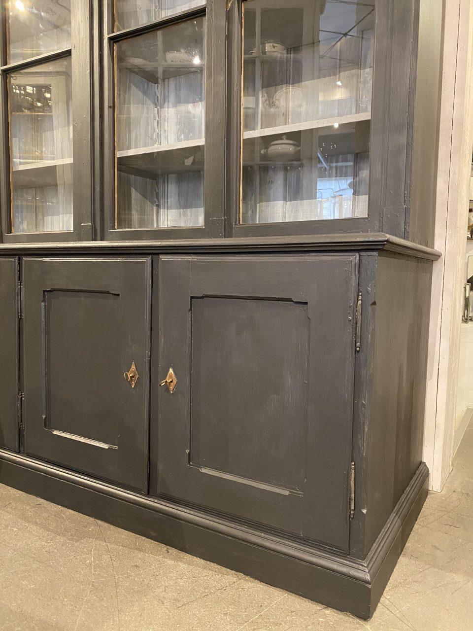 Enormous, handsome and seldom found antique 2 part cabinet / bookcase, from France. 4 beautifully profiled vitrine doors (original glass). The shelves behind are height adjustable. The lower part on the right has practial drawers, and the right side
