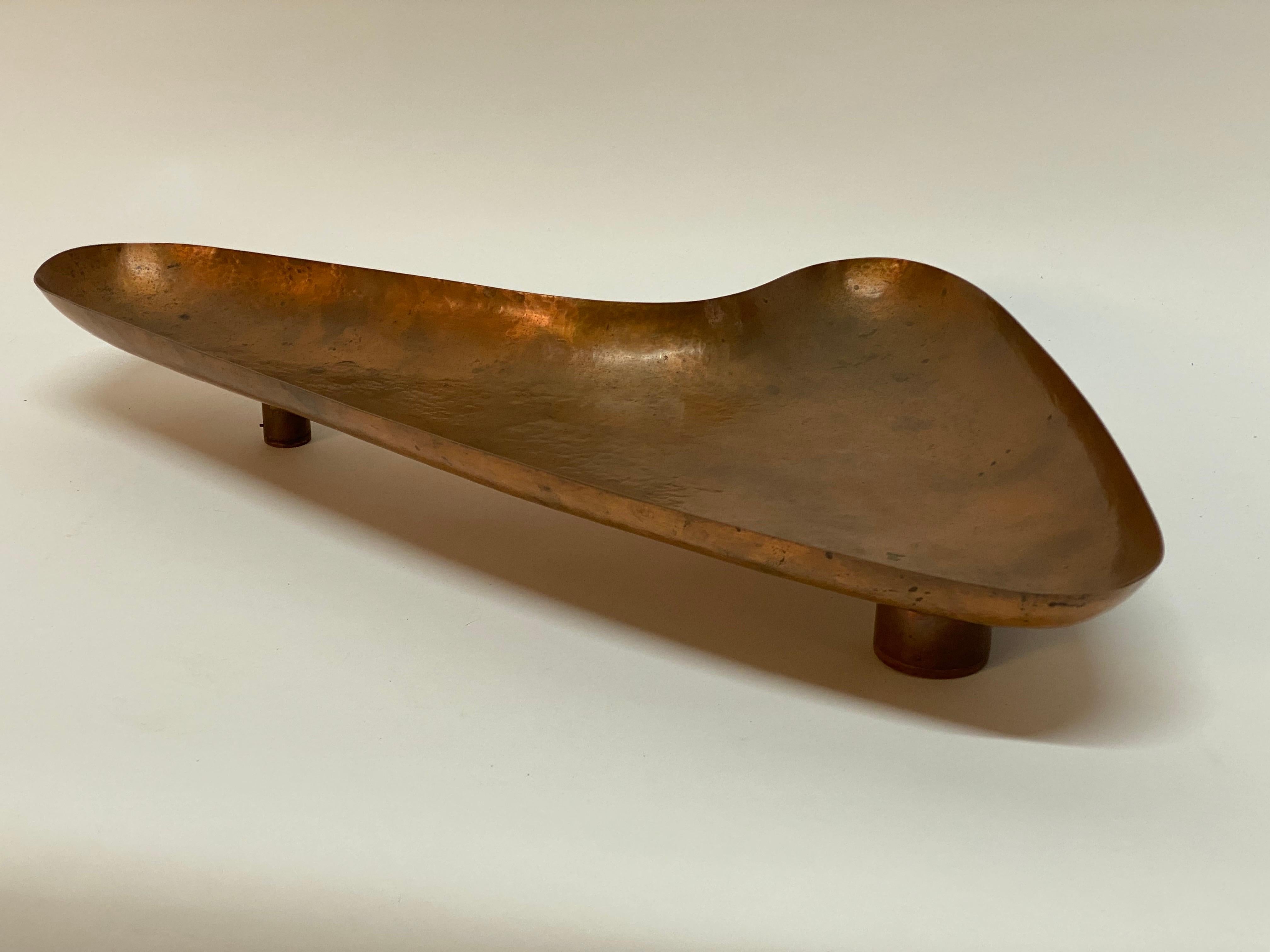 Beautiful hand hammered copper boomerang shaped catchall. Die stamped monogram on the underside, MM, Handwrought. Standing on three wood capped feet. Purchased from a beautiful waterfront home in Greenwich, CT. Circa 1960-70.

Good overall condition