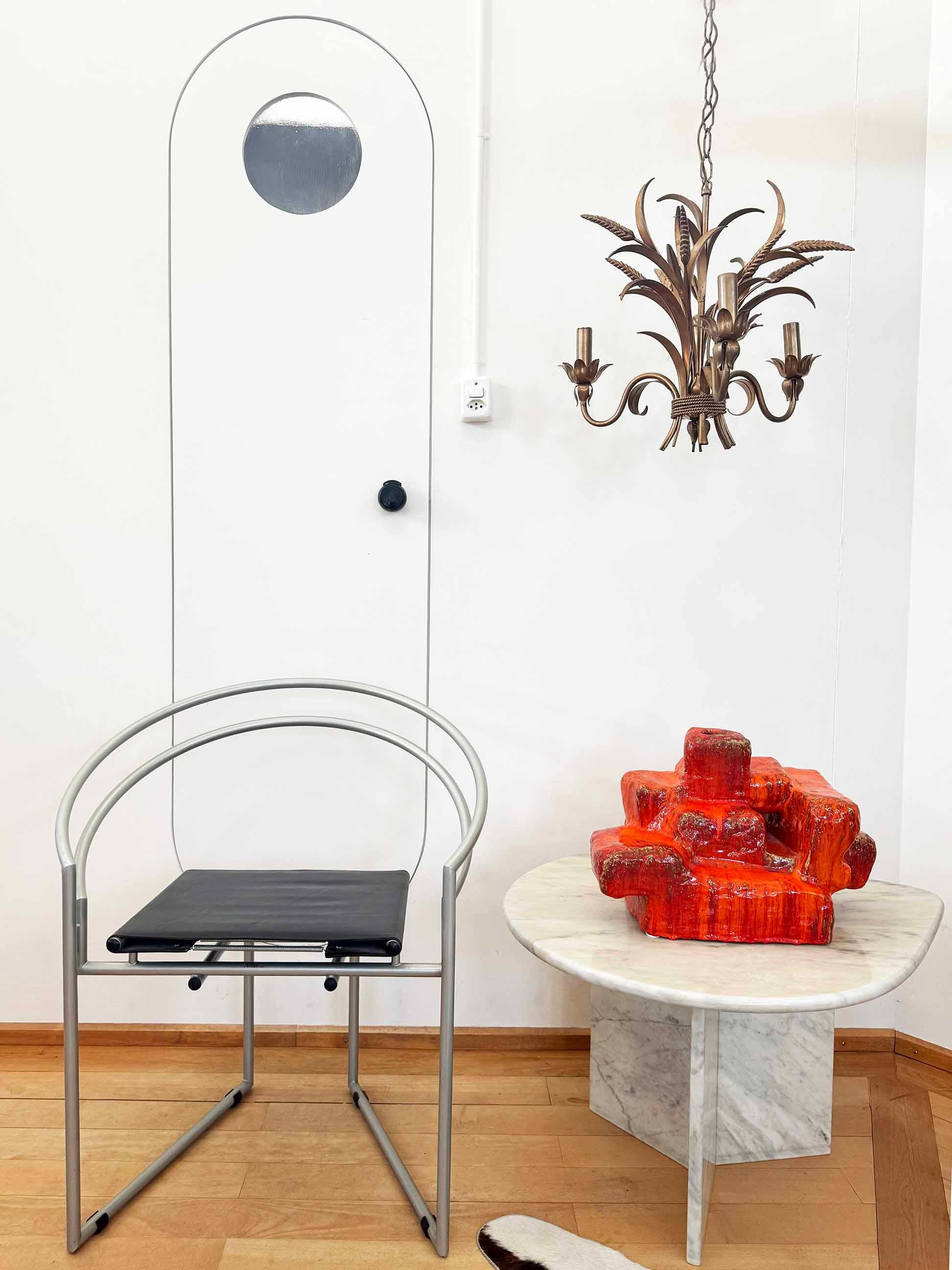 Uno straordinario lampadario / pendente progettato dal designer tedesco Hans Kögl negli anni Settanta.

Questa grande lampada a sospensione, realizzata in Italia nel 1970, incarna lo stile Hollywood Regency, con eleganti mais e accenti floreali.