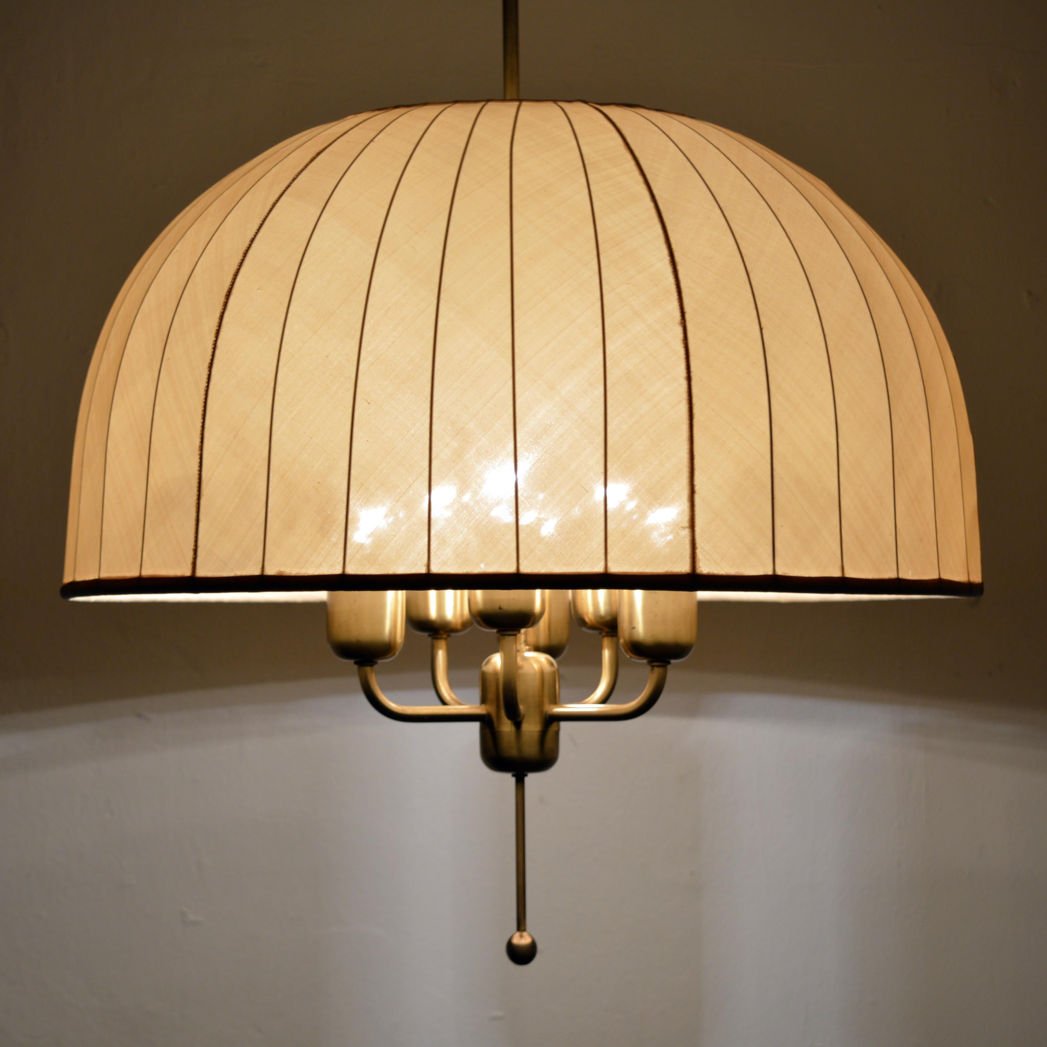 Large ceiling pendant with original shade in beige fabric. Rare model Carolin T549/6 in brass designed 1963 by Hans-Agne Jakobsson. Both lamp itself and the shade are height adjustable.
Minimum height = 85 cm, maximum height = 200 cm. Six bulbs E26