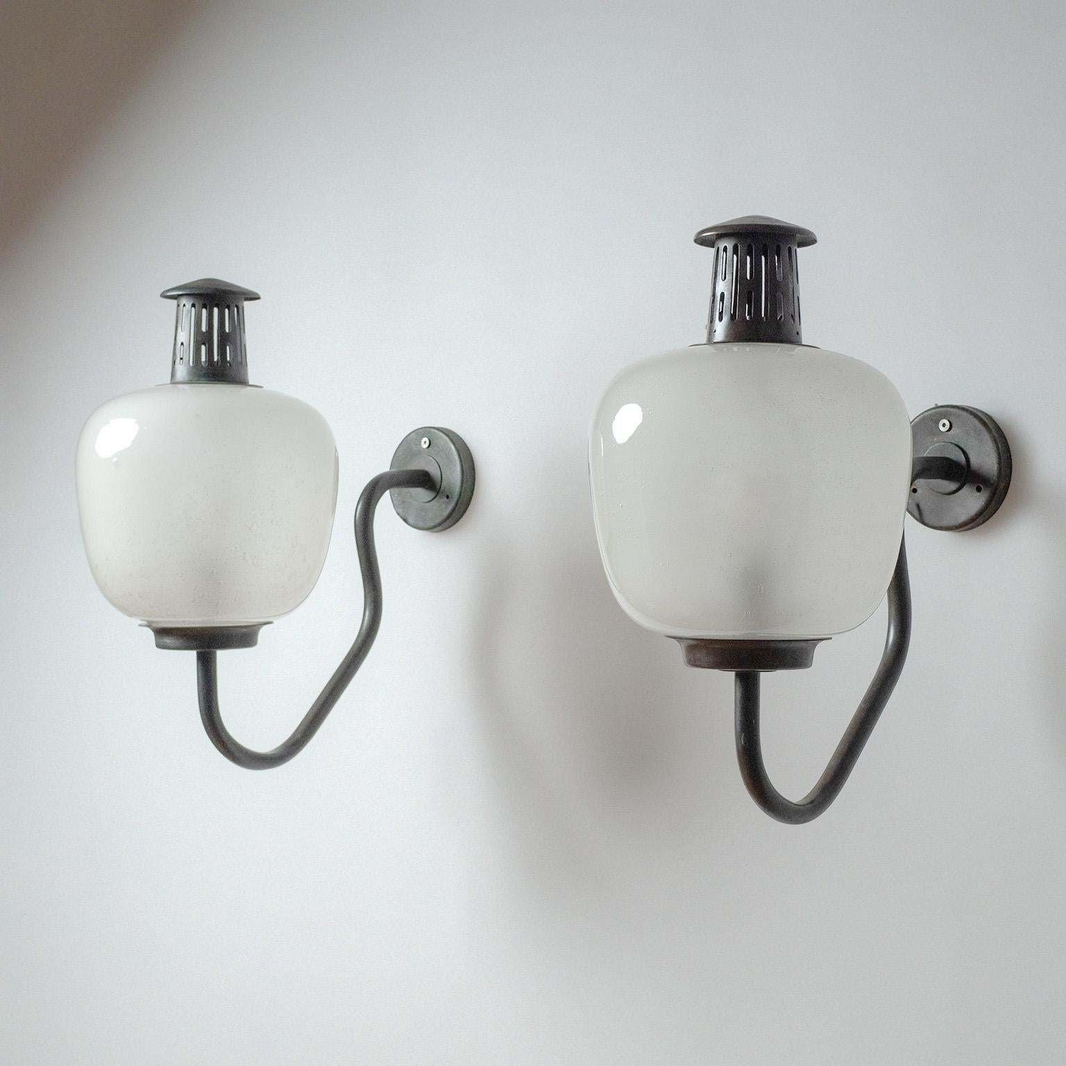 Rare paire d'appliques modèle 1024 en cuivre et verre de Hans Bergström datant du début des années 1940. Joli design à grande échelle avec diffuseurs en verre soufflé et quincaillerie en cuivre massif. Adapté aux espaces extérieurs couverts, le