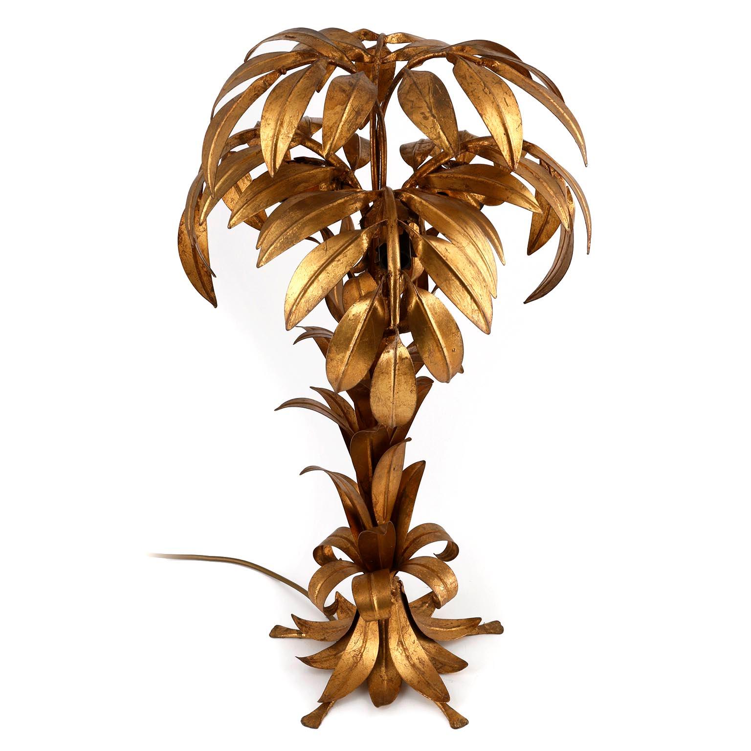 A Hollywood Regency table lamp by Hans Kögl (Koegl or Kogl), Germany, manufactured in midcentury, circa 1970.
A beautiful light fixture in the form of a palm tree made of metal coated with gold leaf. The light has three sockets for small base screw