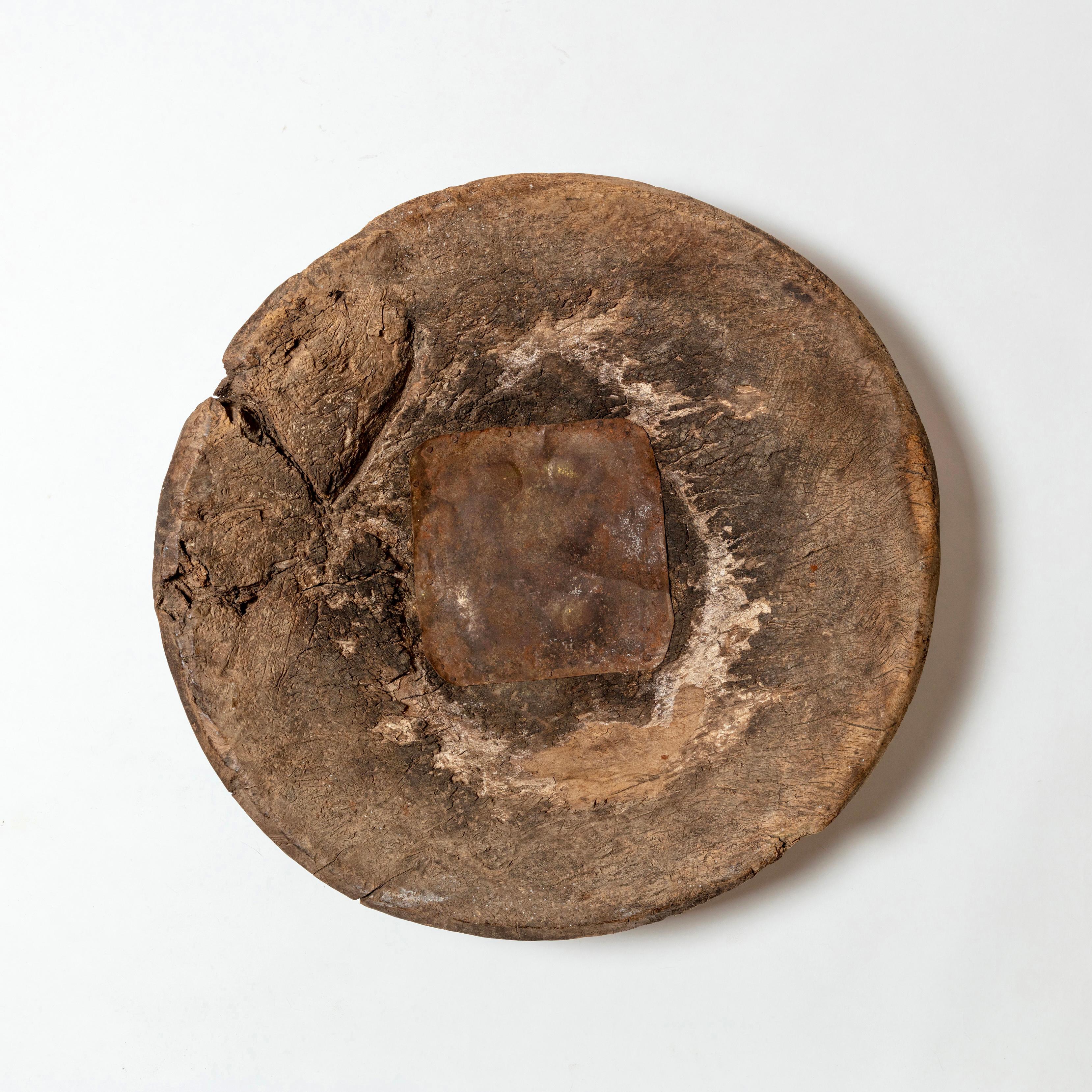 A large-scale, hand-hewn wood mortar bearing evidence of heavy use, including old, primitive tin repairs to interior and underside. Fantastic character, makes a striking centerpiece. 19th century.