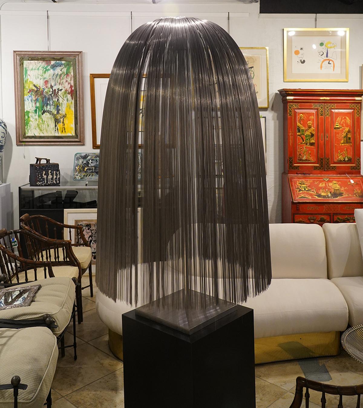Harry Bertoia, American (1915-1978). Kinetic stainless steel wires bundled with steel stem, inserted in base on free standing tube and mounted on square base. Gathered wire sculture took inspiration from the weeping willow tree. Wires are attached