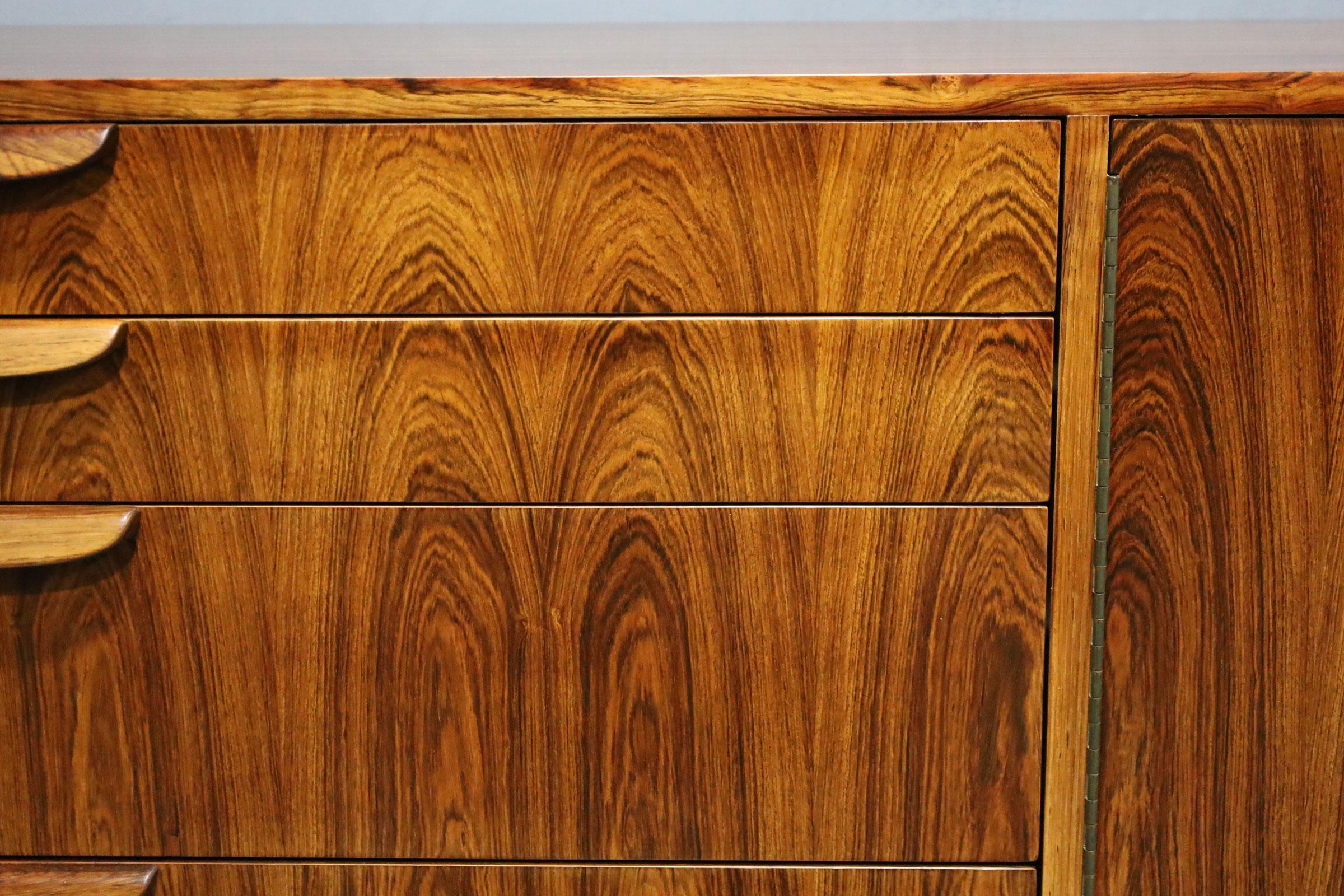 A spectacular large sideboard by Harvey Probber. This sideboard offers plenty of storage. The design is dramatic with a rosewood finish and book matched drawers. This is hard to find piece and will warm up any room with its rich wood grain.