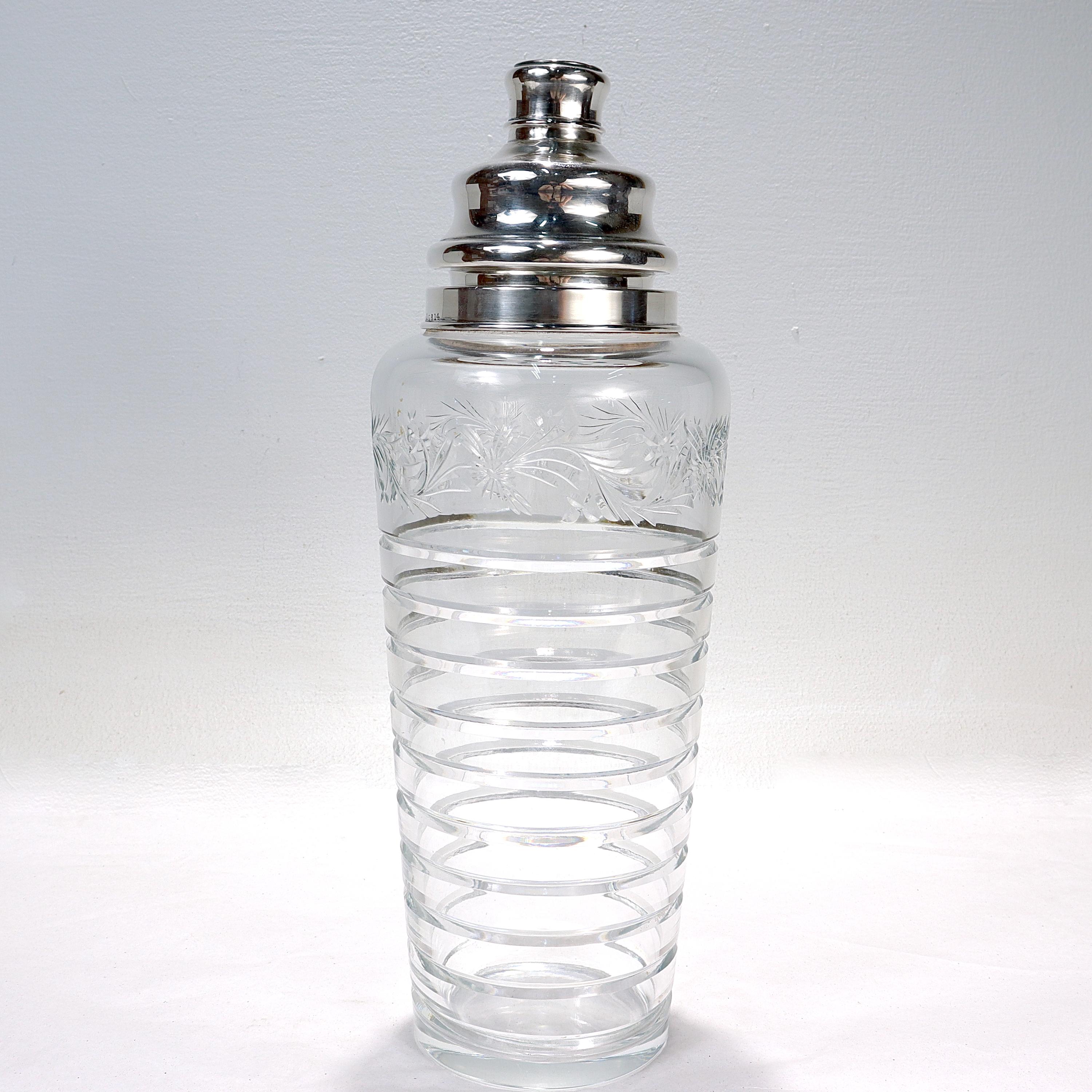 A fine Art Deco glass & silver cocktail shaker.

By Hawkes. 

With a sterling silver lid & rim, cut glass floral decoration and a grooved, ribbed pattern around the body.

Simply a great large-sized cocktail shaker from Hawkes! 

Date:
20th