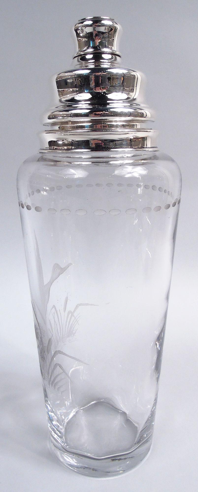 Großer Cocktailshaker aus Sterlingsilber und Glas. Hergestellt von Hawkes in Corning, New York, um 1925. Hohe und spitz zulaufende Glasschale. Auf der Außenseite säuregeätzte Fliegen, die aus ihrem Versteck zwischen den Rohrkolben hervorlugen. Oben
