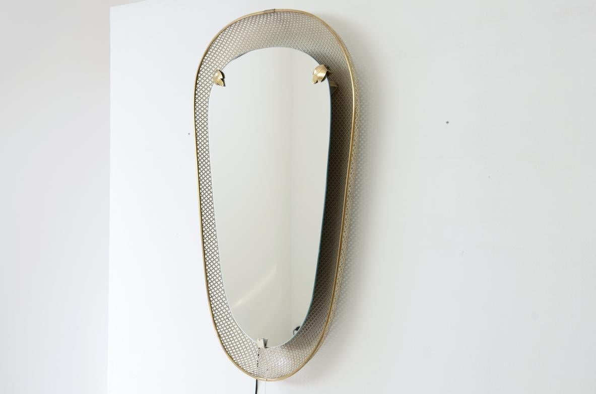 Large and rare heart-shaped backlit mirror in curved metal mesh with brass details and ground mirror.

Italian manufacture, early 1950s

