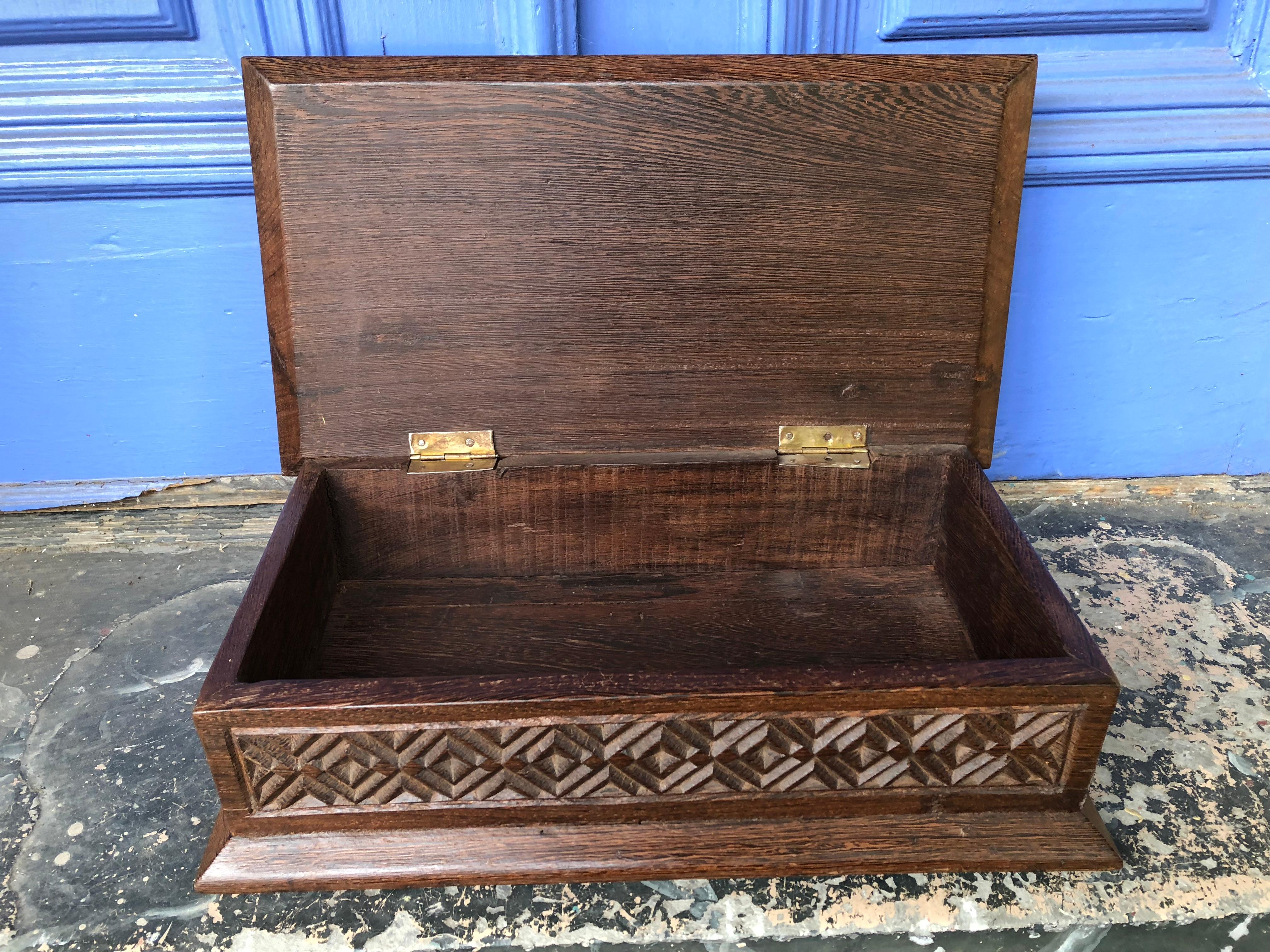 This old large stained oak box is a show stopper. The top and sides are carved with a repeating geometric pattern. It is very solid. Hinges work well. It's only flaw is a split in the wood on the bottom which shows age but has not affected its