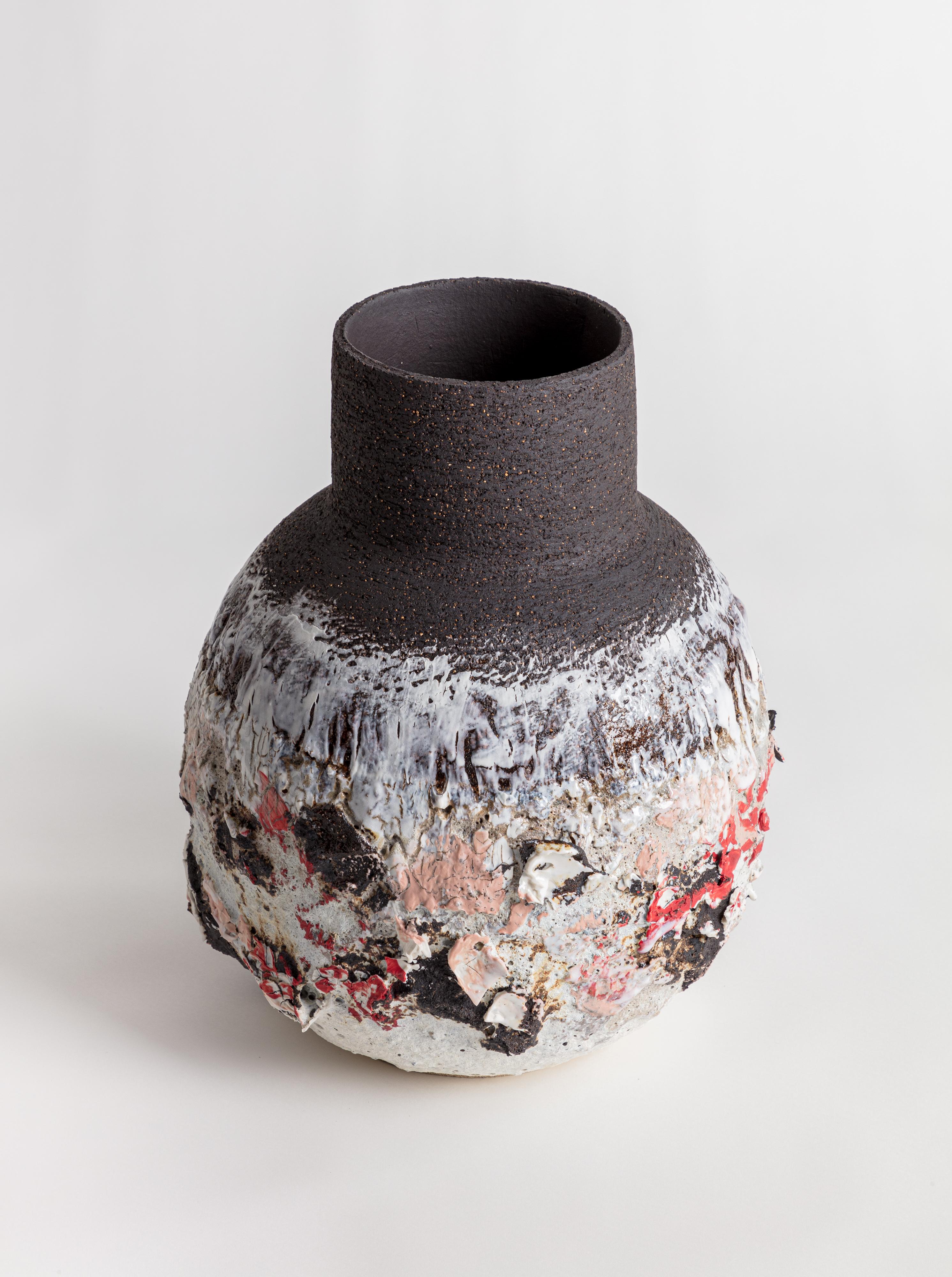 A large heavily textured volcanic vase with black, white and brown glaze and markings. Wide necked vessel with a bellied form. Made from black textured stoneware clay and porcelain.

Inspiration for the piece comes from the clay itself and the