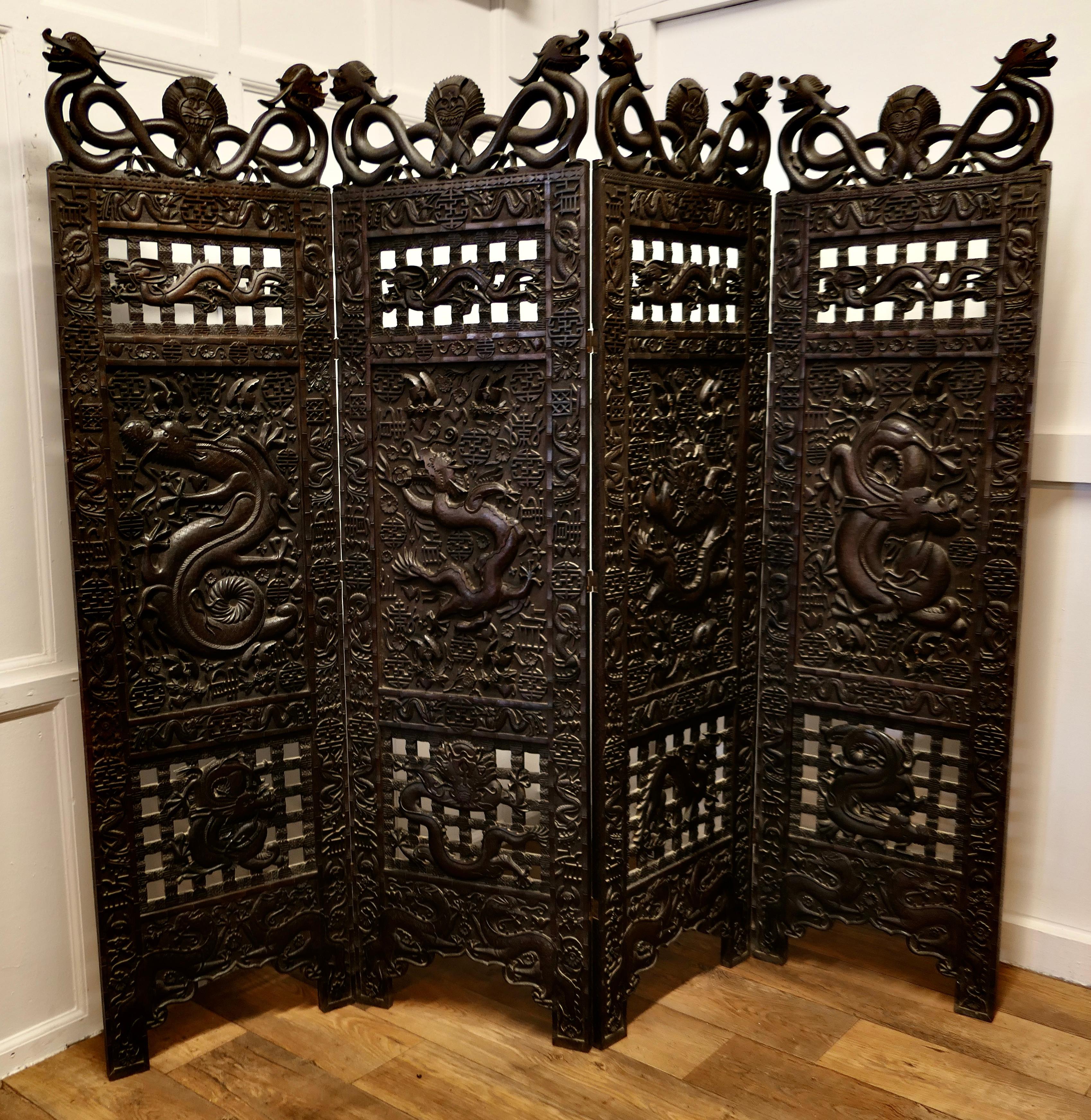 Large Heavy 19th century Carved chinoiserie 4 Fold Screen

This very impressive privacy screen has four large and profusely carved panels, the design is of very many dragons and serpents, each panel has a pair of dragons at the top
The screen is