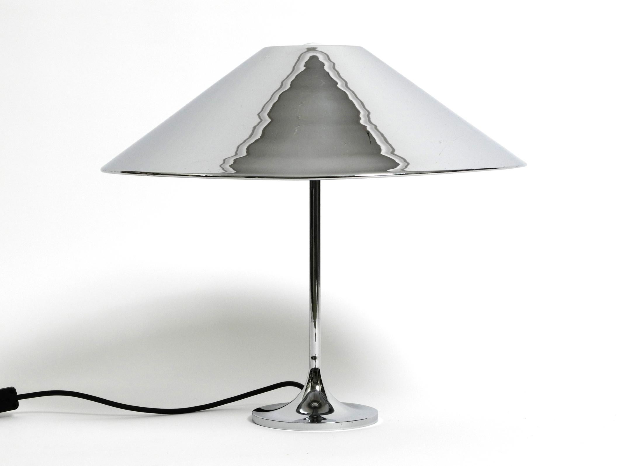 Large heavy 1970's metal chrome table lamp with metal shade. Timeless high quality design.
The foot and neck are made of chrome-plated iron, the shade is made of sheet steel and is also chrome-plated.
The shade is simply placed on the three metal