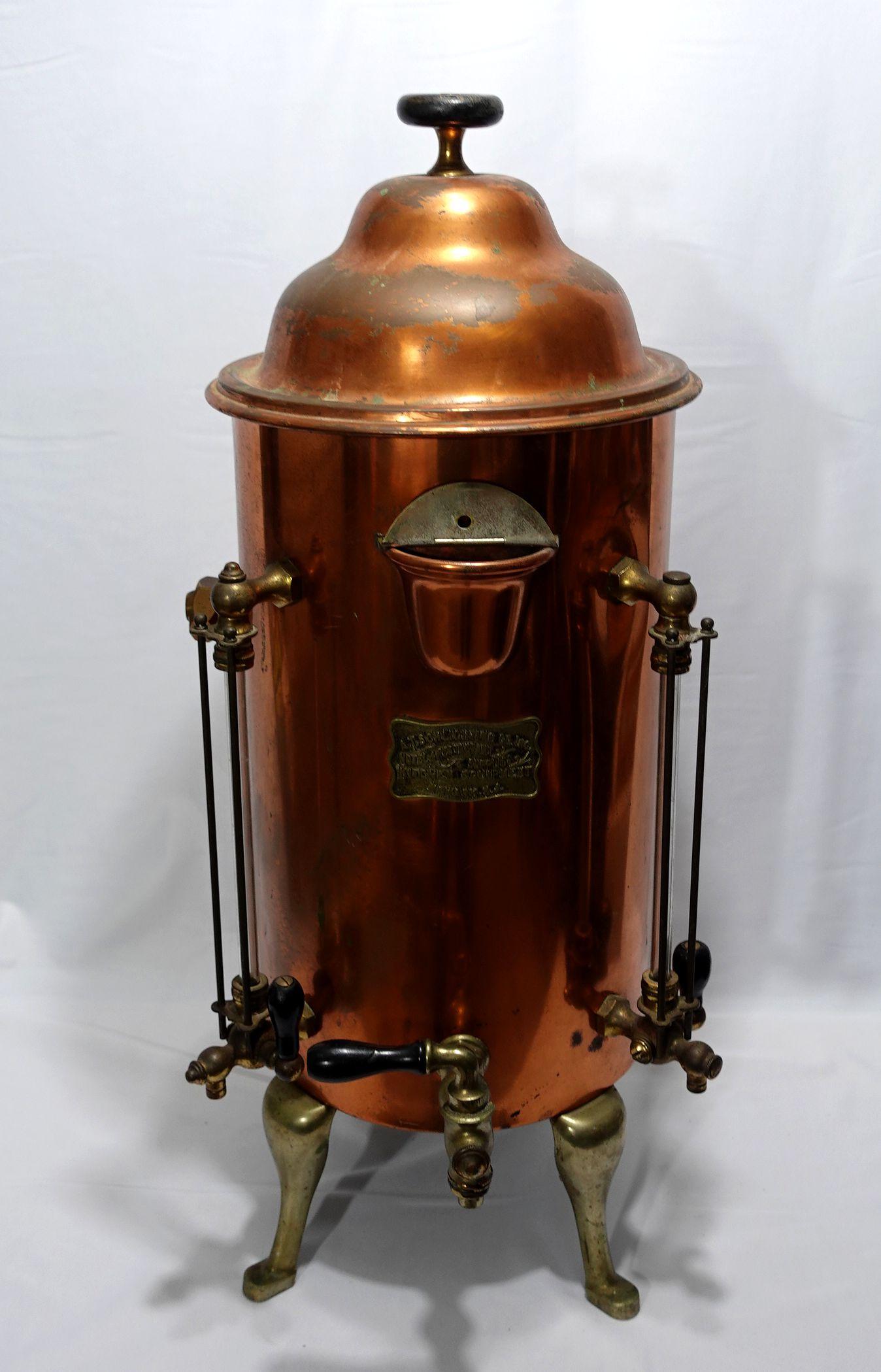 Large and heavy brass and copper hot water dispenser or coffee maker with attached brass label reading A. T. Schlighting Co. Inc. Hotel and Restaurant Supplies Kitchen equipment, Newark N.J. 32” h. x 12” diameter,