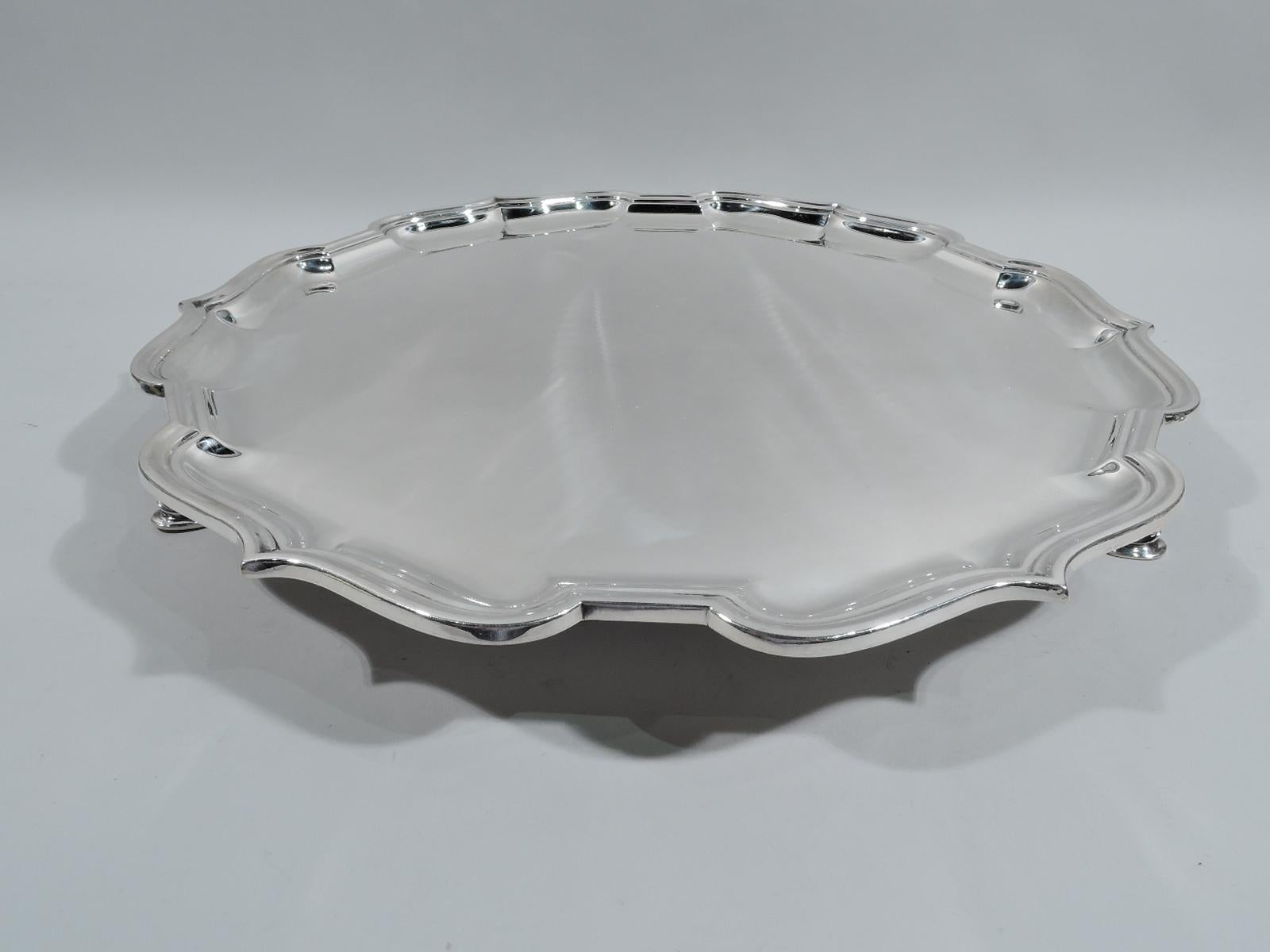 George VI sterling silver salver. Made by Mappin & Webb in Sheffield in 1945. Molded curvilinear rim with ogee arches. Three hoof supports. Large and heavy in traditional Georgian form. Fully marked. Weight: 61 troy ounces.
