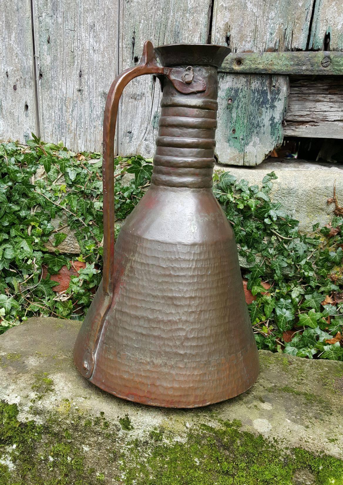 A very sculptural and tactile Turkish copper water jug of some age with a lovely patina. Beautifully hand beaten copper with domed base tapering to a narrow neck with hand formed rings and scalloped rim. Handle is riveted to the body, there is a