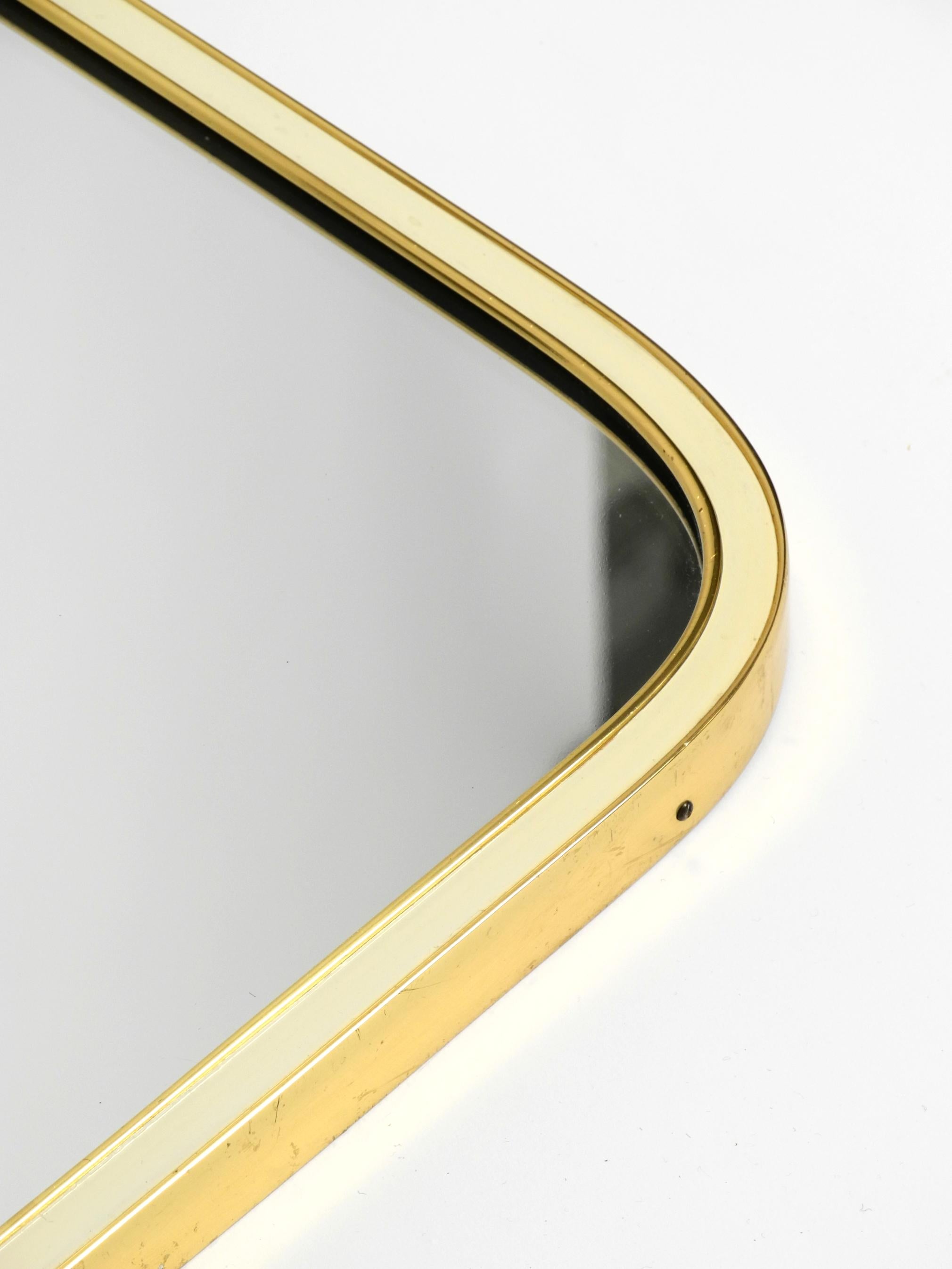 Large heavy long Mid Century brass wall mirror by Münchner Zierspiegel For Sale 7