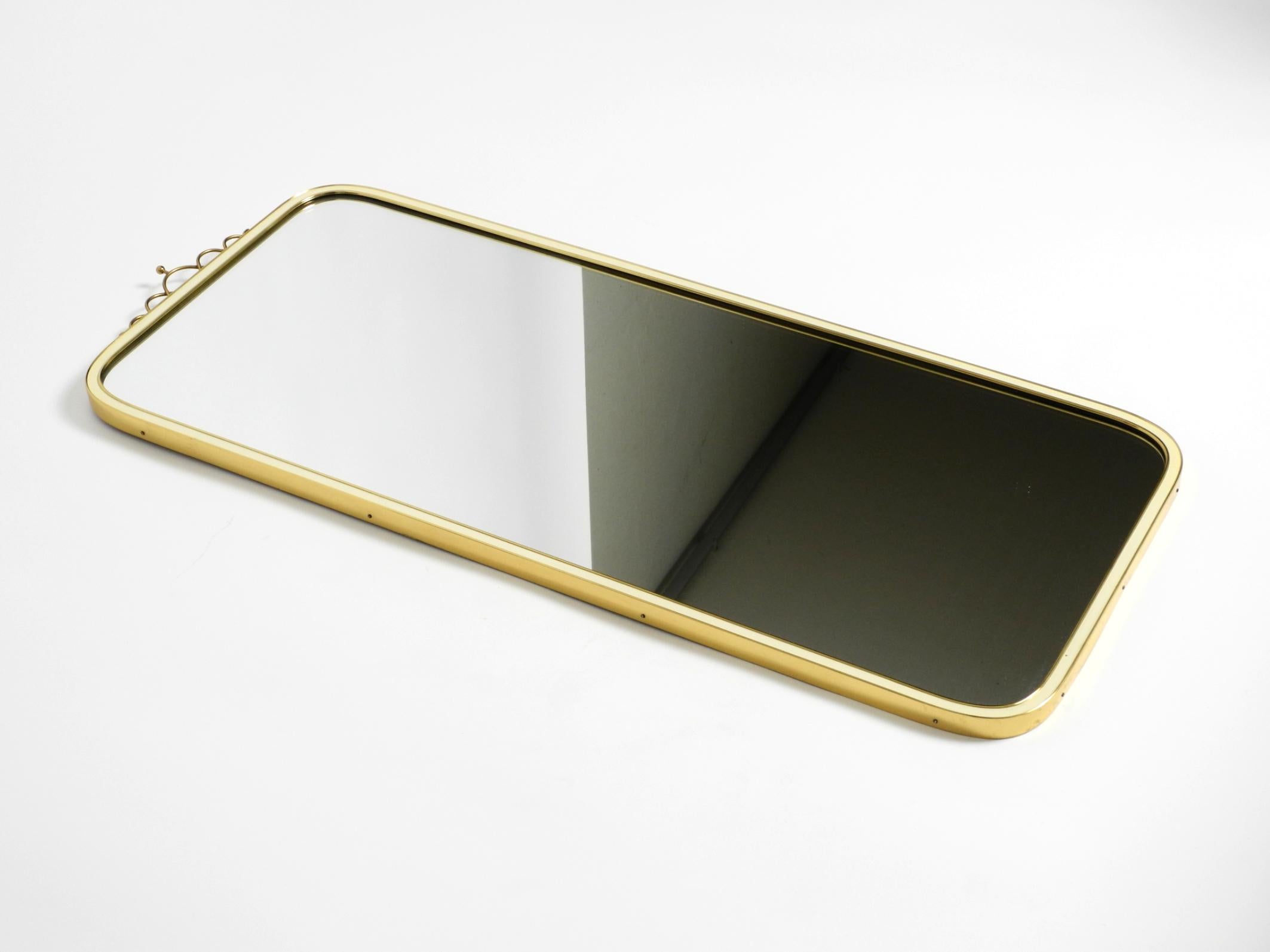 Large heavy long Mid Century brass wall mirror by Münchner Zierspiegel In Good Condition For Sale In München, DE