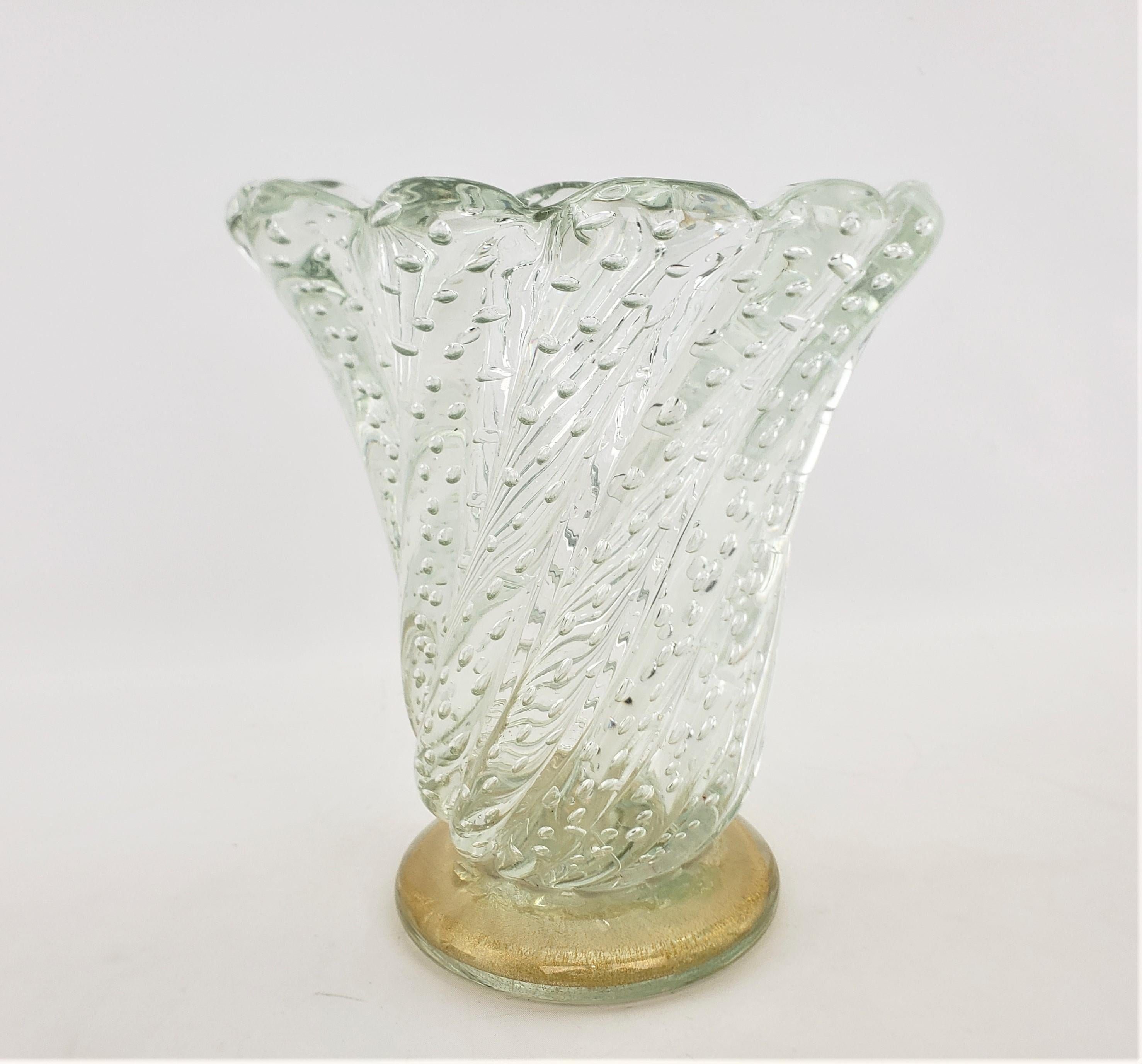 This large and substantial art glass vase is unsigned, but presumed to have been done in Murano Italy in approximately 1965 in a Barovier Mid-Century Modern style. The vase is done with a very thick clear glass that has a ribbed swirl from the base