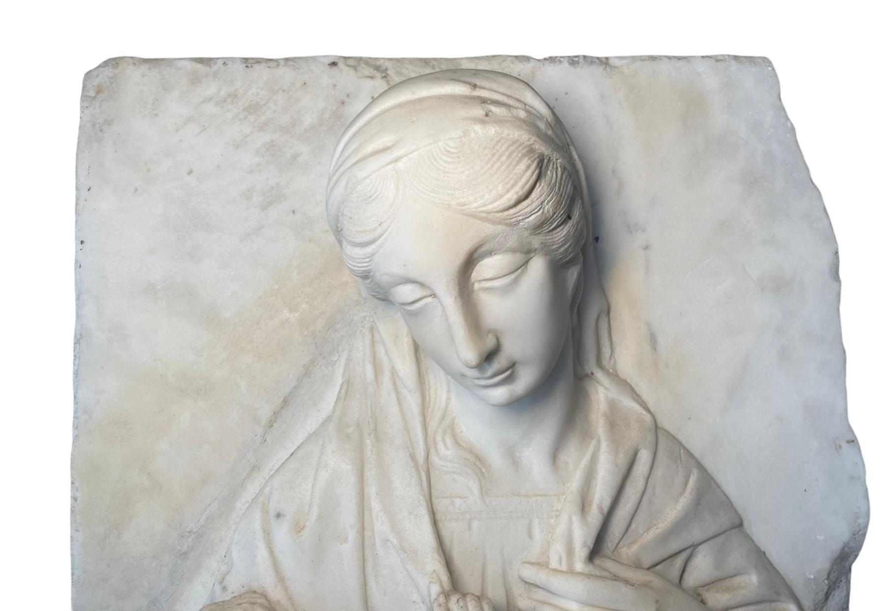 This is a large heavy rectangular carved marble relief of the Madonna and Baby Jesus. It depicts a caring Virgin Mary holding baby Jesus with her right hand and looking down to Him. He is semi nude covered with a cloak while his right hand is