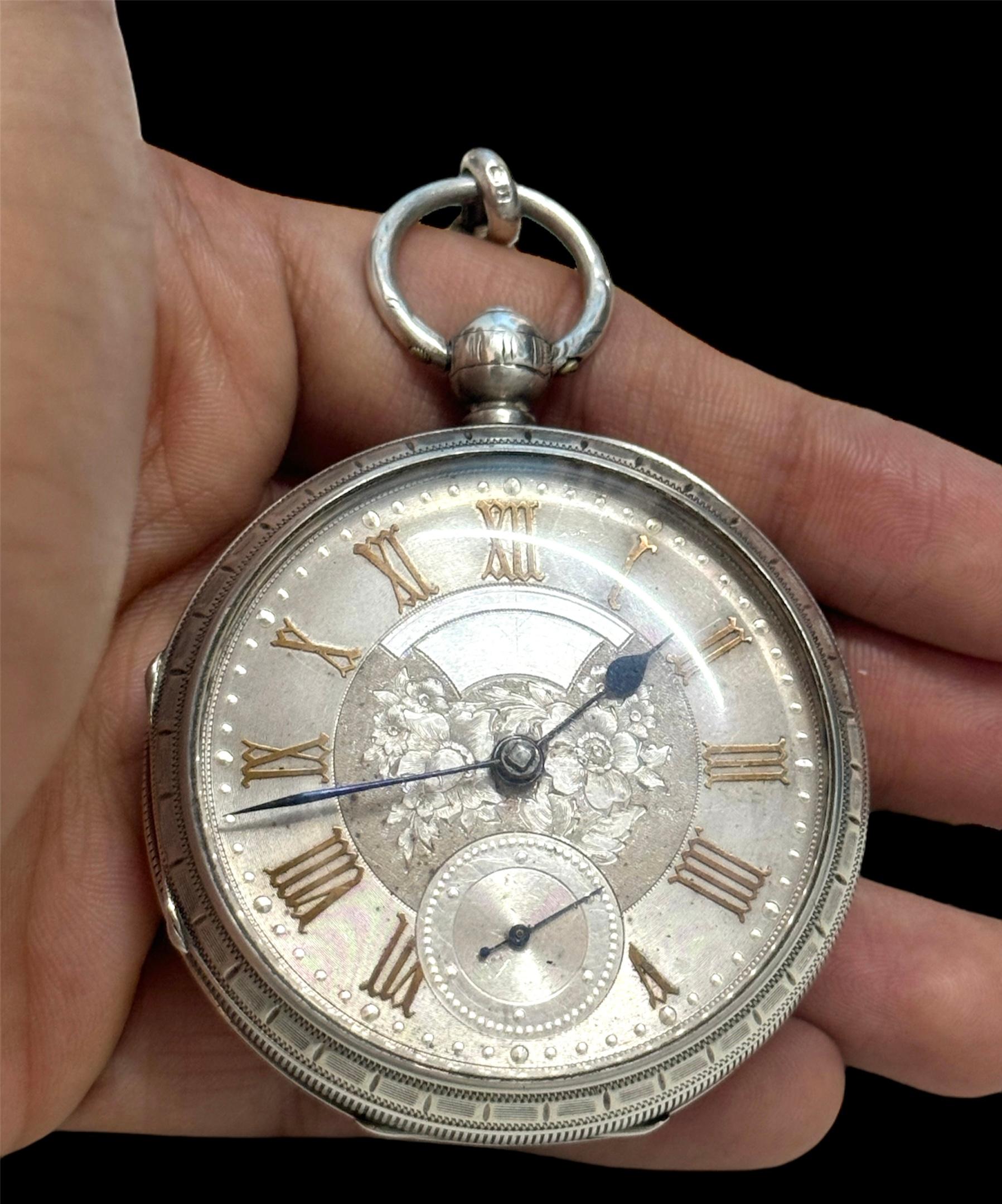Mid Victorian Period - English Lever Large / Heavy Sterling Silver Ornate Open Faced Pocket Watch with Attached Sterling Silver Albert Watch Chain, T-Bar and Coin. Hallmark Birmingham 1869. Features Silver Dial, English Lever, Ornate Dial. Total