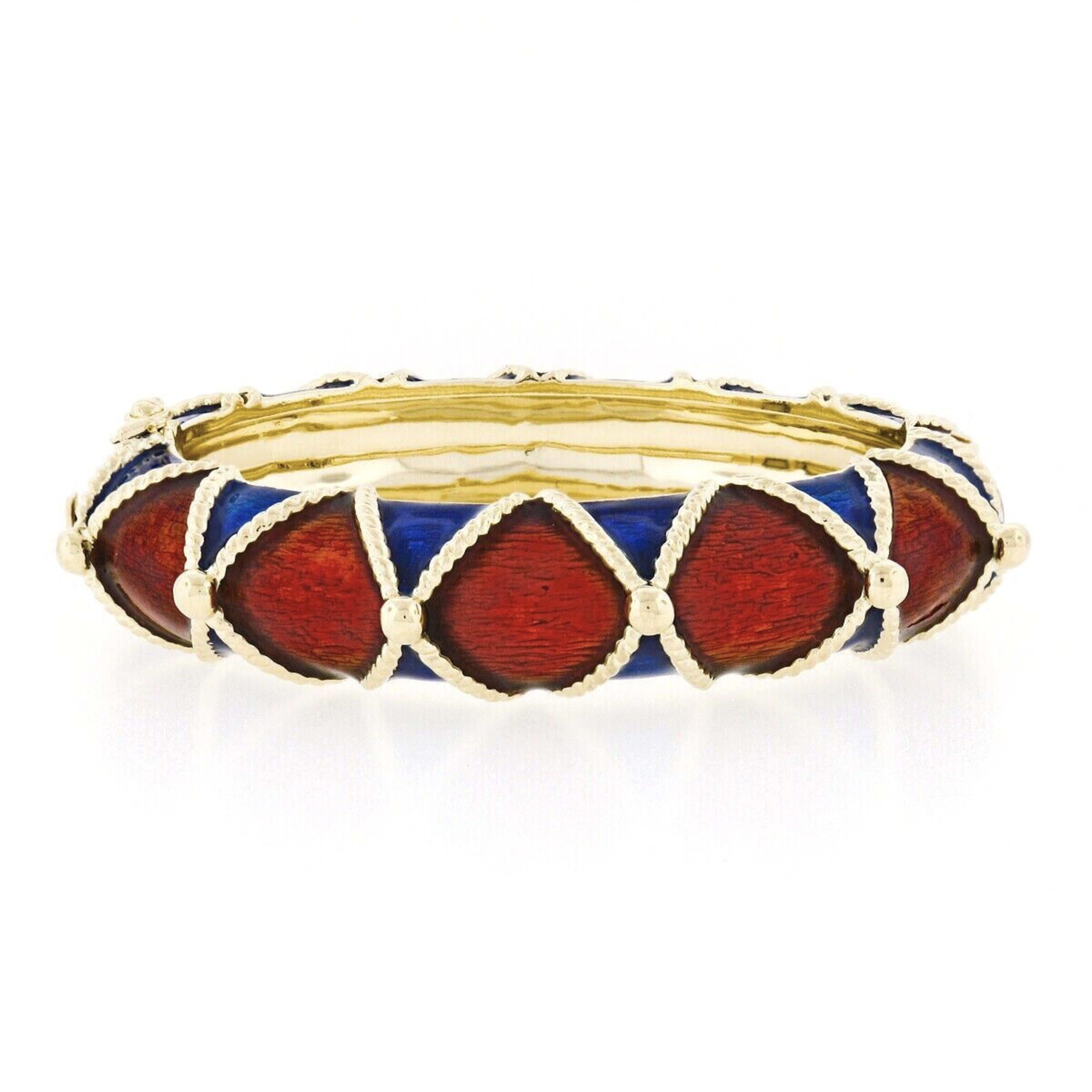 This substantial vintage bangle bracelet is well crafted in solid 14k yellow gold and features wide domed design decorated with gorgeous brownish-red enamel along the center and royal blue enamel all around the sides. The fine enamel covers and