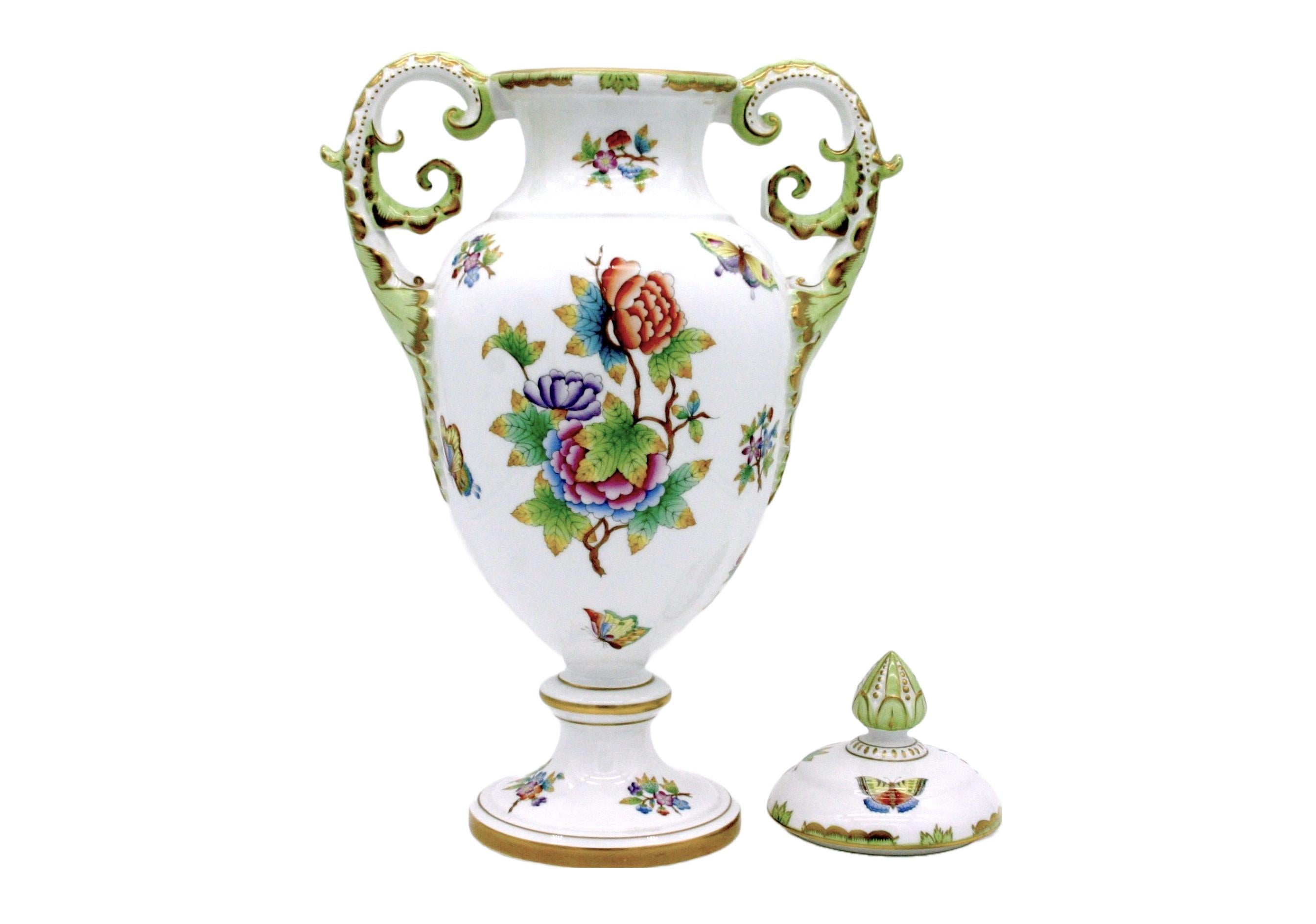 Classic Herend Queen Victoria pattern is transformed from special dinnerware into a beautifully decorated urn/vase . Stunning art in its own right , the handles of the urn/ vase are ornately handcrafted dragons with feathered wings accented with