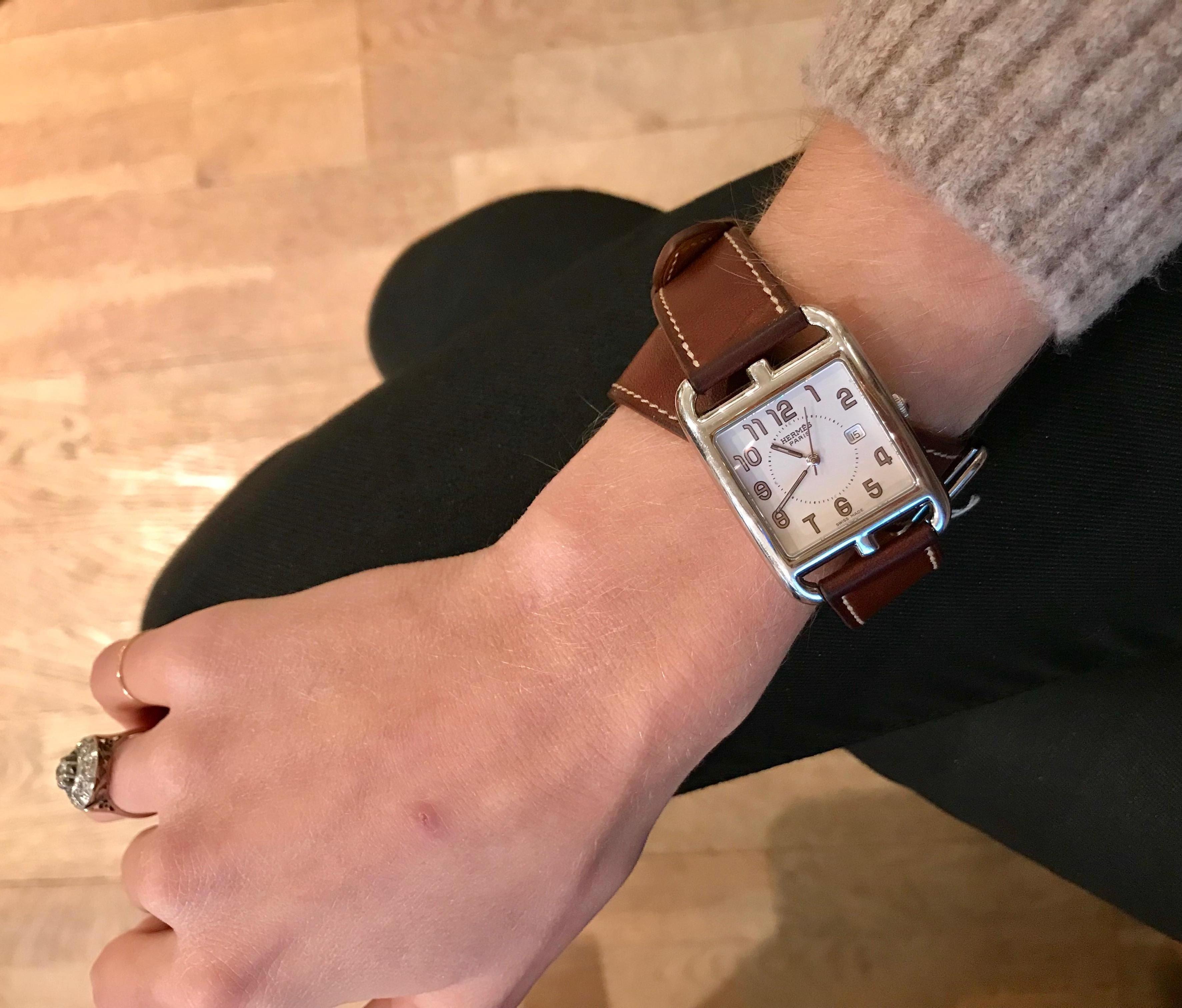 Hermès “Cape Cod” watch in stainless steel.

White dial, Arabic numerals, date at three o’clock, Luminescent hands and hour-markers.

Dial's Dimensions: 29 X 29 mm

Quartz movement.

Double turn bracelet in barenia leather with white
