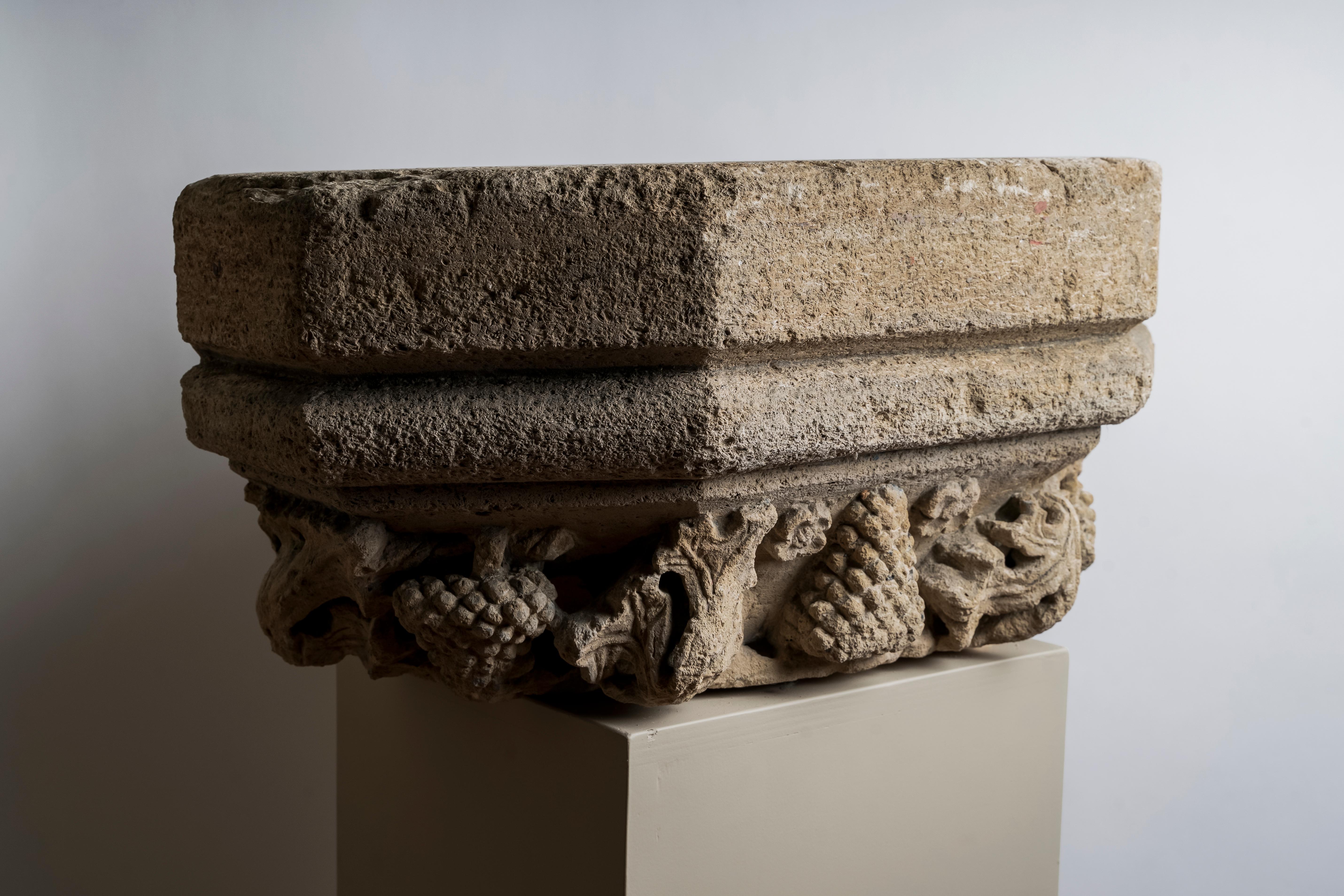 Large base of molded hexagonal pilaster in burgundy stone carved with vines, grapes and rosettes in high relief. 
Burgundy, 15th century
28 x 63 x 30 cm
Provenance : collection Demotte

This very large pilaster base decorated with vines leaves