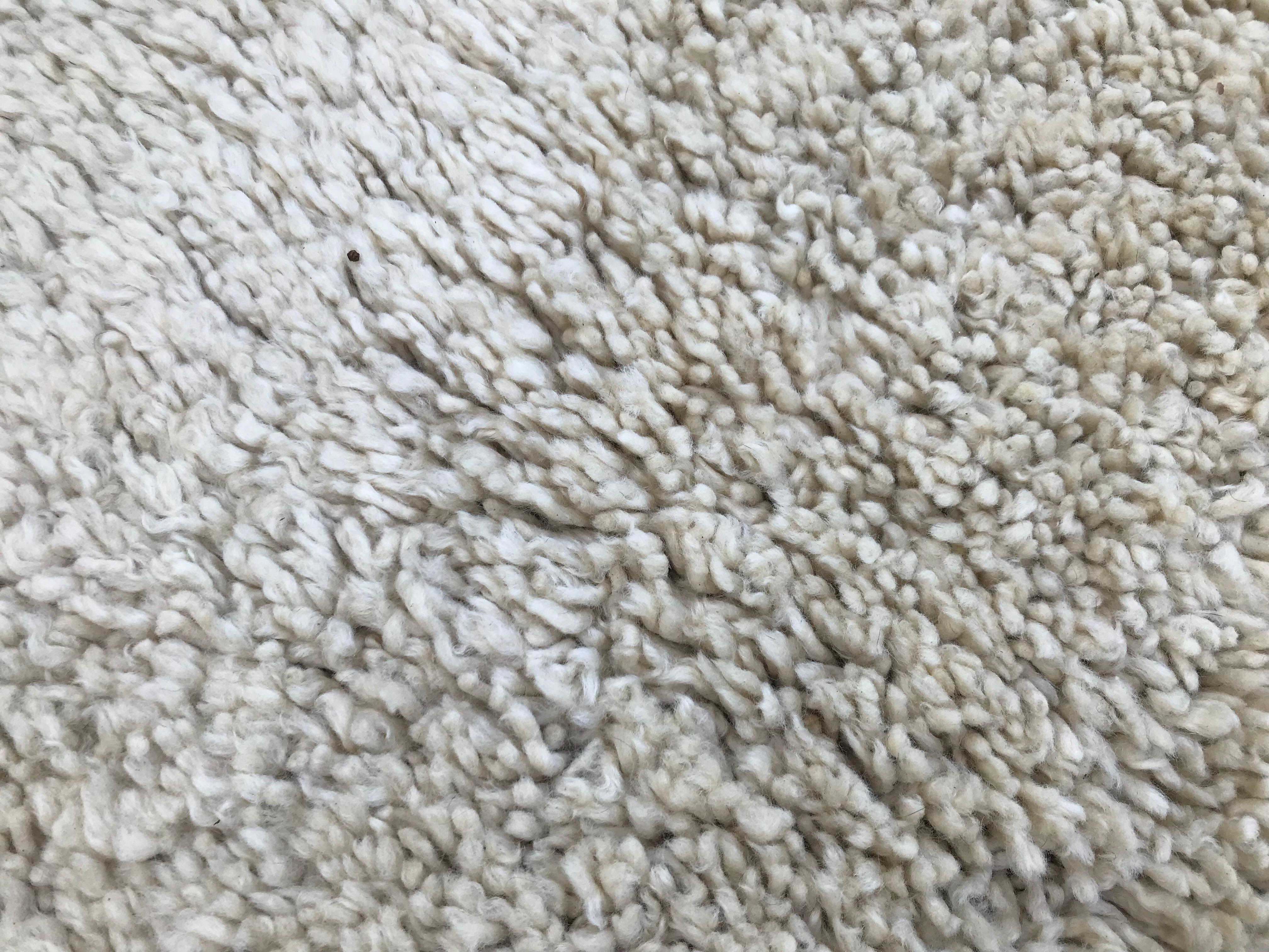 Very thick high pile cream round wool rug, with cotton backing. It is probably from the 1970s or 1980s and it did not seem to have been used much or maybe it is because of the quality of the work and the wool.