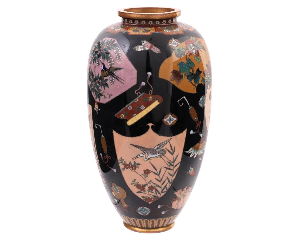 A large antique Japanese Cloisonne , late Meiji period, enamel over gilt copper vase.
The vase has an amphora shaped body and a fluted neck.
The ware is enameled with polychrome medallions and panels depicting cranes, birds and butterflies in
