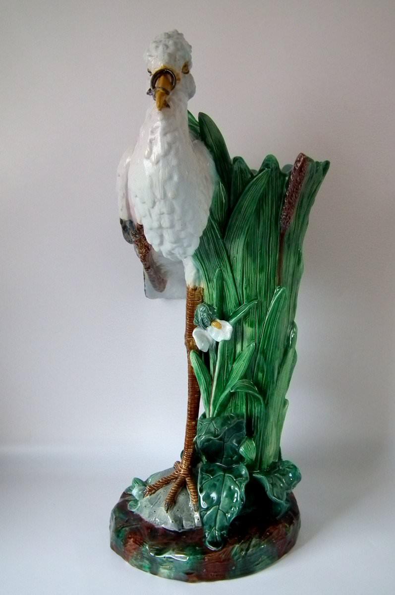 Holdcroft Majolica stick or umbrella stand which features a stork stood beside bulrushes, with a snake in its beak. Coloration: green, white, brown, are predominant. The piece bears maker's marks for the Holdcroft Pottery.