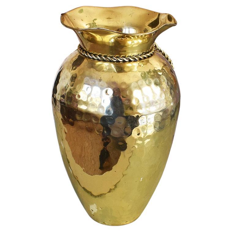 A beautiful Mid-Century Modern brass Trompe L'oeil ribbon vase. This lovely piece is created from brass and is decorated with faux ribbon details around the neck. 

This vessel would be fabulous on a small table, or nightstand with your favorite