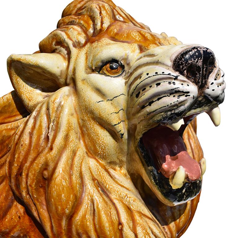 Italian ceramic lion sculpture from Italy. This ceramic piece is a fantastic example of the Hollywood Regency style. Hand painted and glazed in various hues of brown, orange, black and white.

The animal is seated on all four paws and gives a