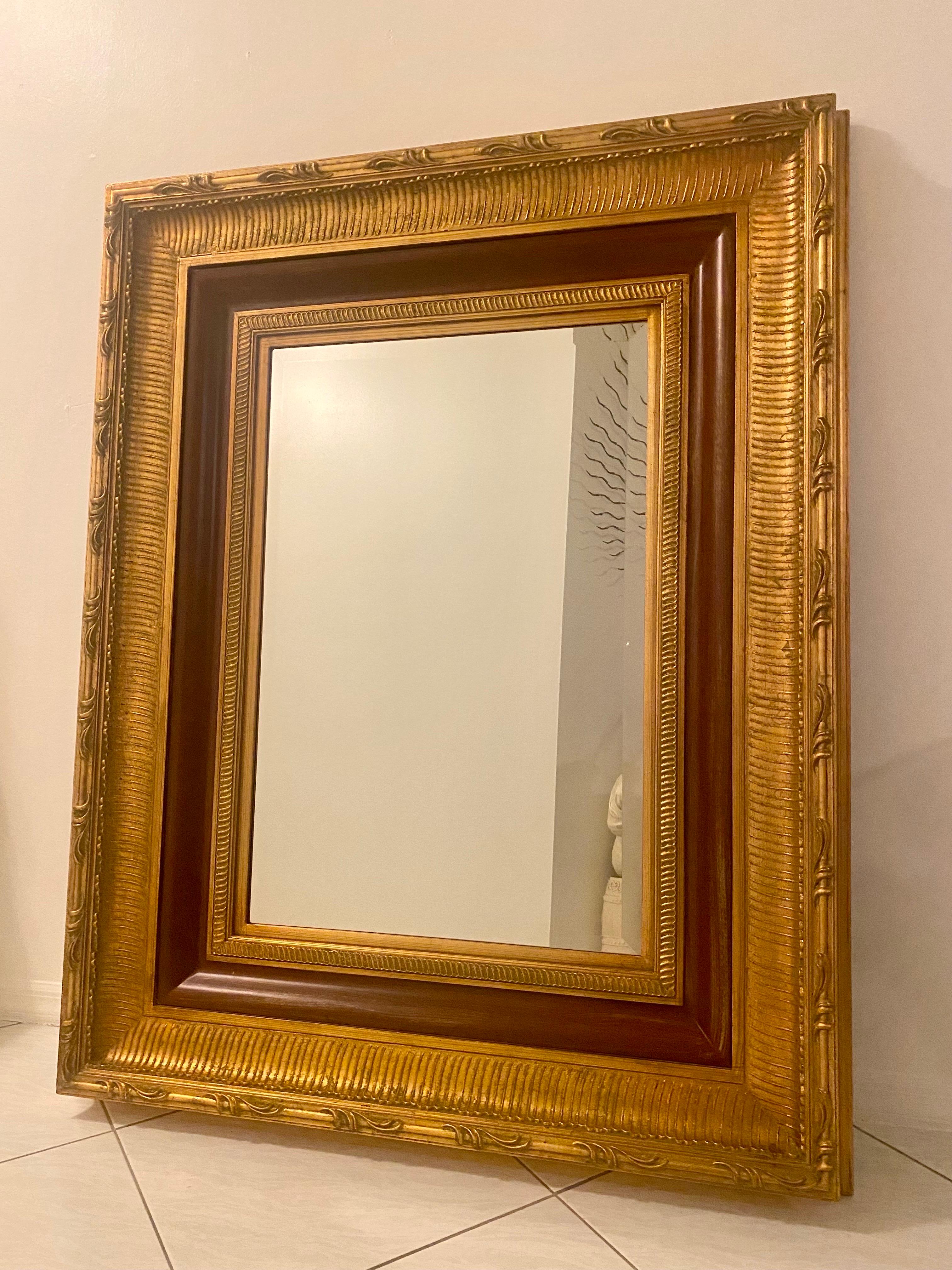 Ein großer, hochwertiger, vergoldeter Holzspiegel in sehr gutem Zustand aus einem Nachlass in Palm Beach. Er ist im Hollywood-Regency-Stil gehalten und besteht aus schwerem, luxuriösem Vergoldungsholz und einem Aufhängesystem aus Metall. Der Spiegel