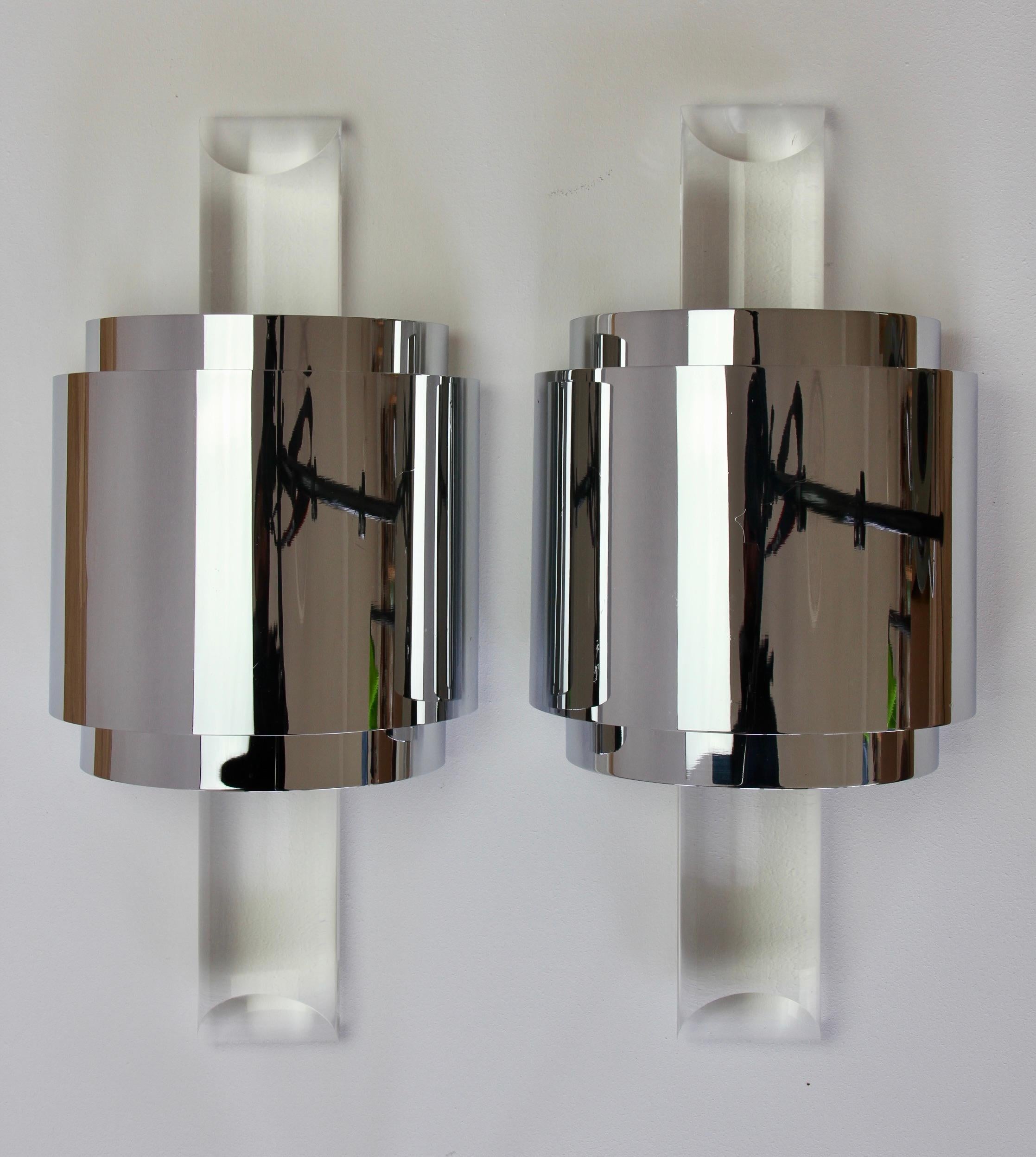 Hollywood Regency style pair of large, oversized pair of cut / angled acrylic / lucite wall-mounted lamps, lights or sconces in the style of Karl Springer and made in the latter part of the mid 20th century circa 1975 -1985. These illuminate