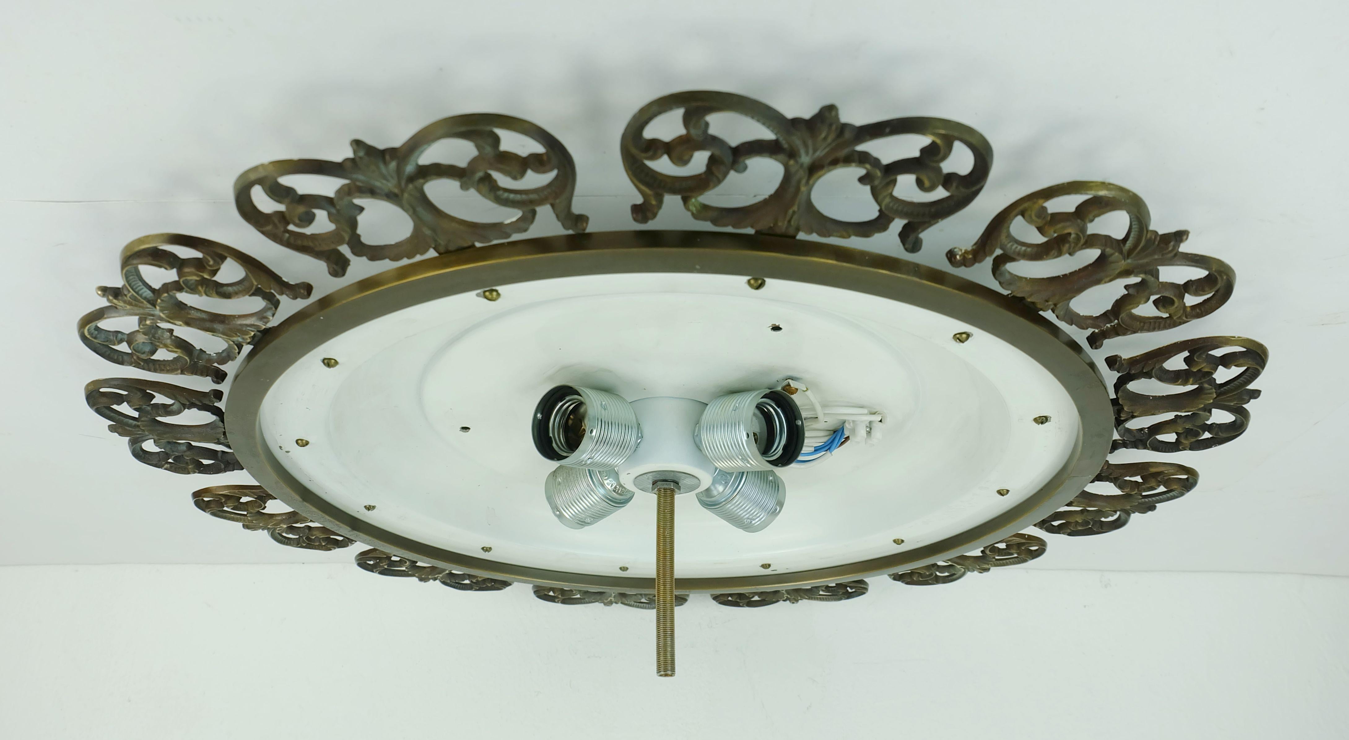 Impressive large ceiling fixture manufactured in the 1970s. The base is made of white lacquered metal. Ice glass shade made of structured glass surrounded by a ornated brass frame. Holds 4 E27 bulbs. 

Diameter 22 1/2