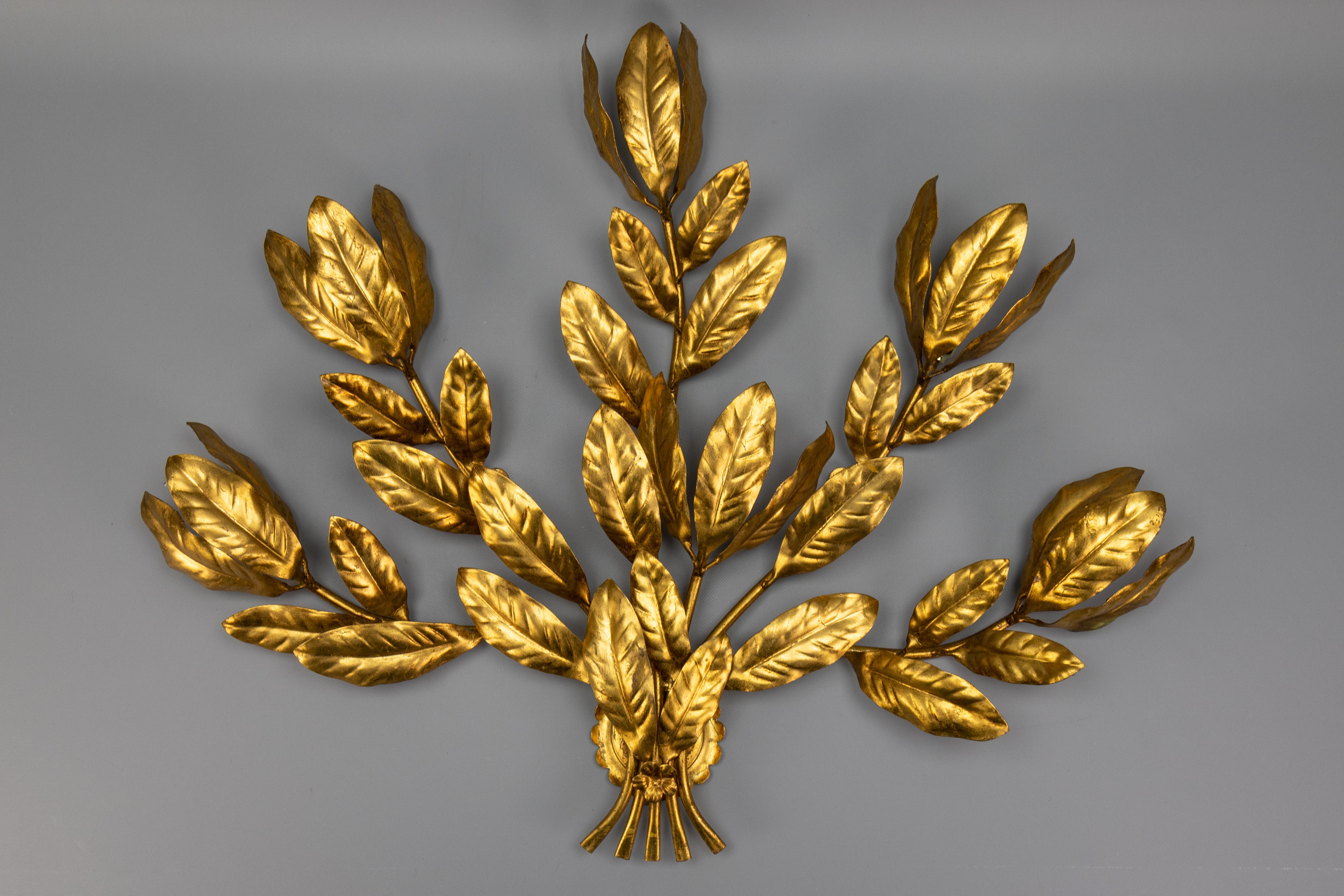 Applique a sei luci in metallo dorato in stile Hollywood Regency, attribuita a Hans Kögl, degli anni '70 circa.
Questa imponente e grande lampada da parete in metallo dorato in stile Hollywood Regency presenta bracci a forma di ramo con bellissime