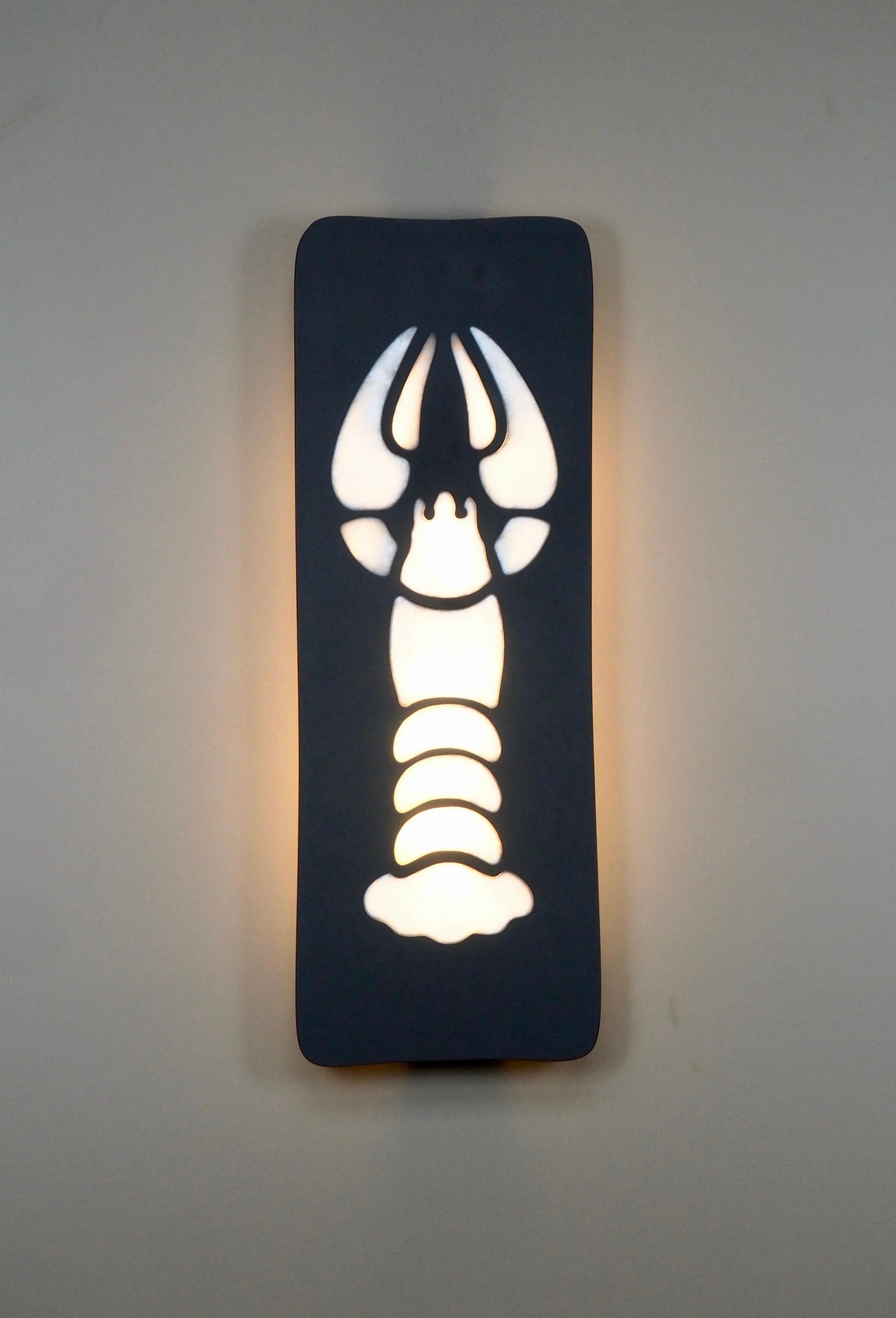 Cette grande applique est composée d'une plaque d'ardoise polie de 2 cm d'épaisseur avec une inclusion de cristal de roche en forme de homard stylisé. 

L'éclairage est assuré par deux grandes ampoules E27/E26 de 30 cm protégées par un diffuseur