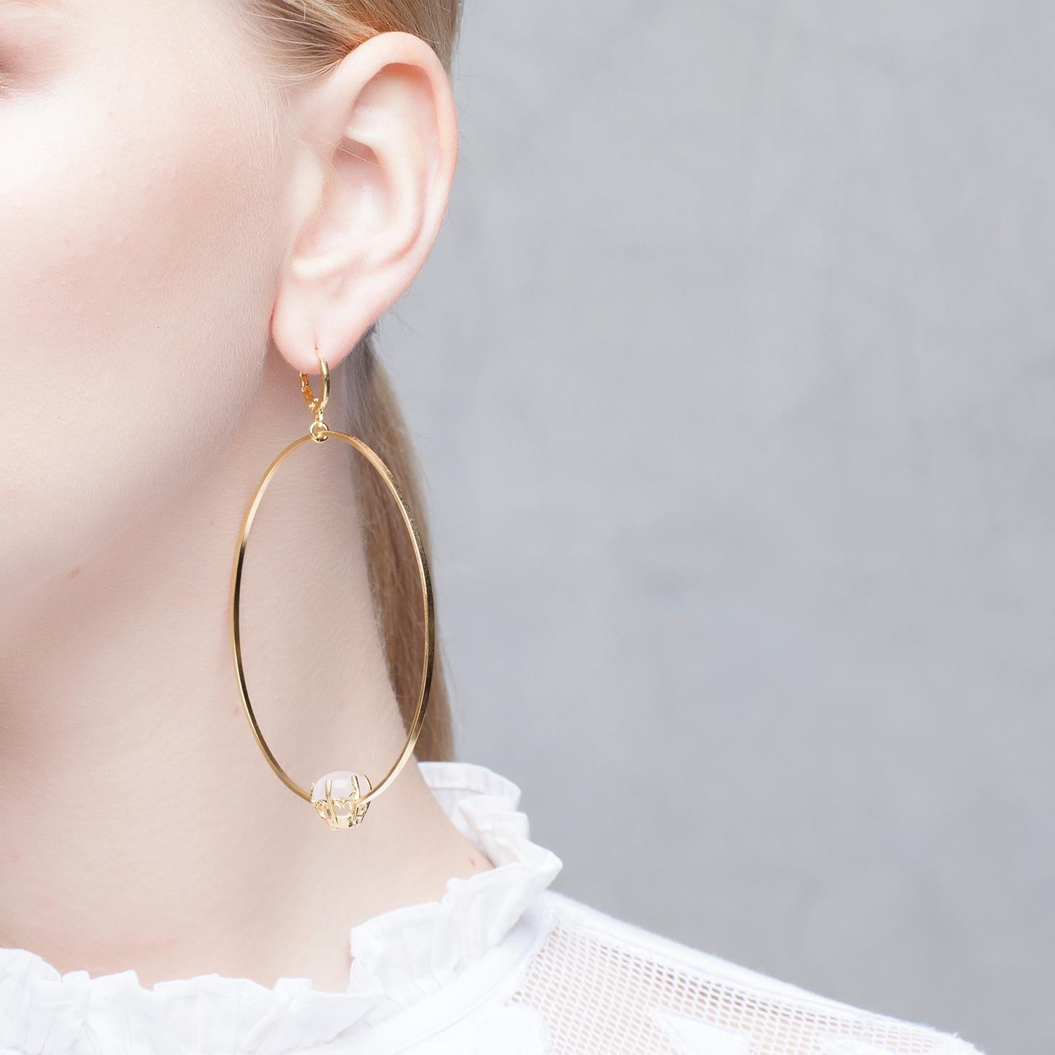 Puro Iosselliani presents its iconic creole big hoop earrings. Made in 18 Karat gold plated silver in Italy, the big hoops float effortlessly by a vintage lever back hook. A reversed green round malachite stone embellishes the hoop for extra