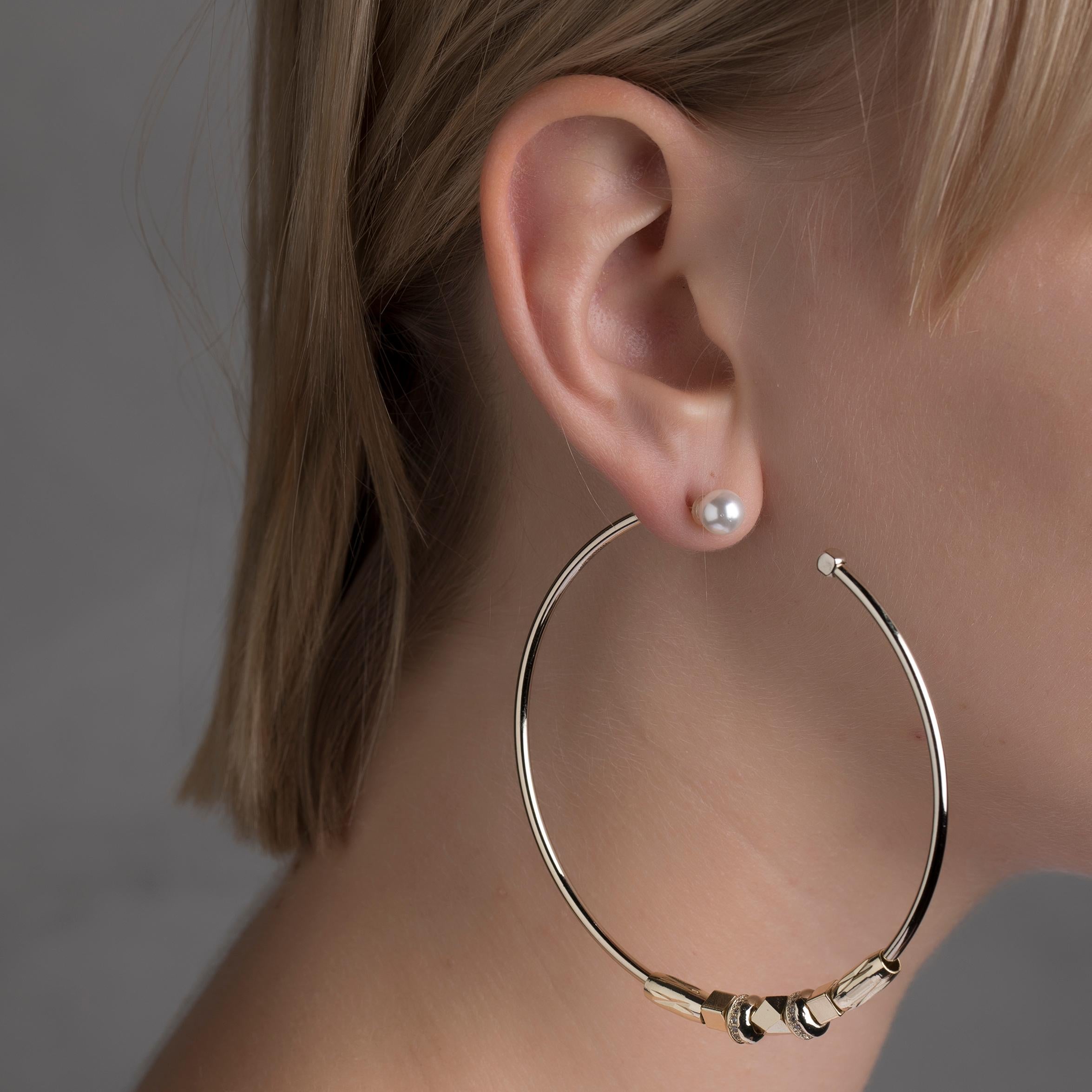 Classic hoops are reimagined by IOSSELLIANI to create these reversible earrings that are designed with diamond cut brass beads embellished with cubic zircons all around.
The pair features a choice of of stoppers in three different materials: a