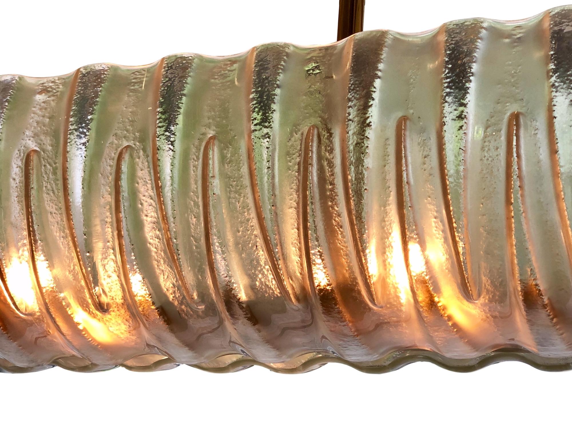 Eine italienische Leuchte aus geformtem Glas und Messing aus den 1960er Jahren mit 12 Innenleuchten.

Abmessungen:
Länge 62